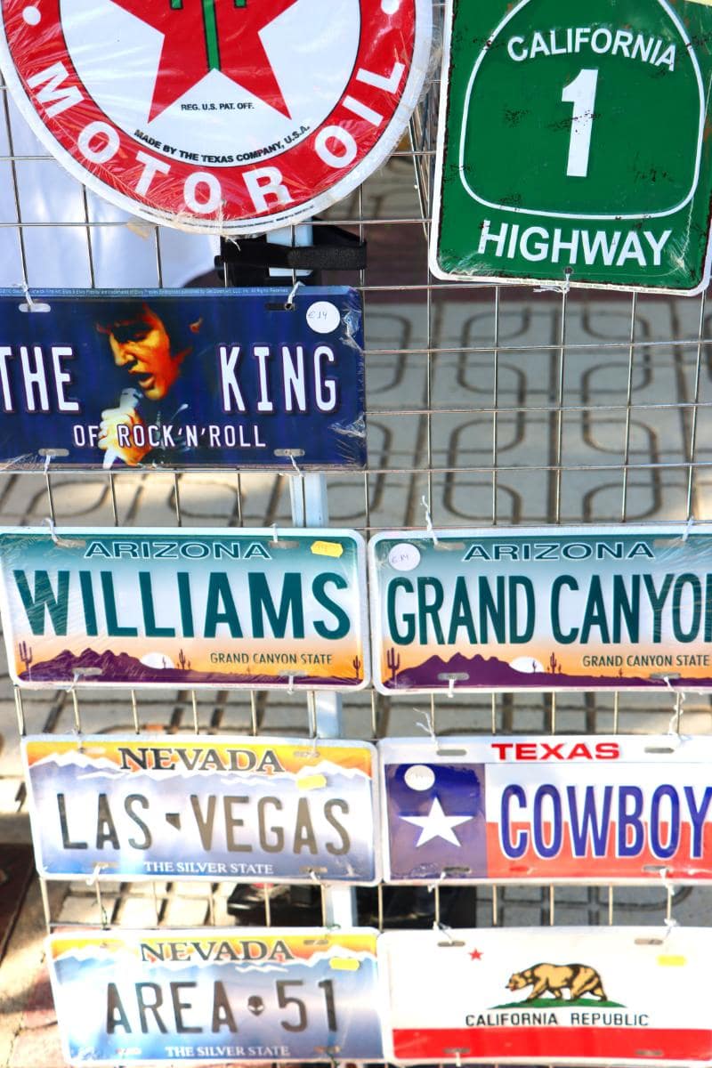 Una muestra de varias placas de matrícula decorativas, incluidas las de Las Vegas, el Gran Cañón y una señal de carretera de California, creadas con un borrador automático.