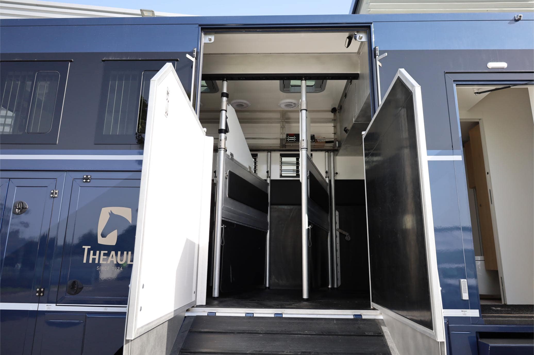 El interior de un vehículo de transporte de caballos cuenta con puertas abiertas y divisiones para los establos de los caballos, lo que garantiza un fácil acceso y organización. Una característica inherente de borrador automático agrega eficiencia al mantener la limpieza con un mínimo esfuerzo.