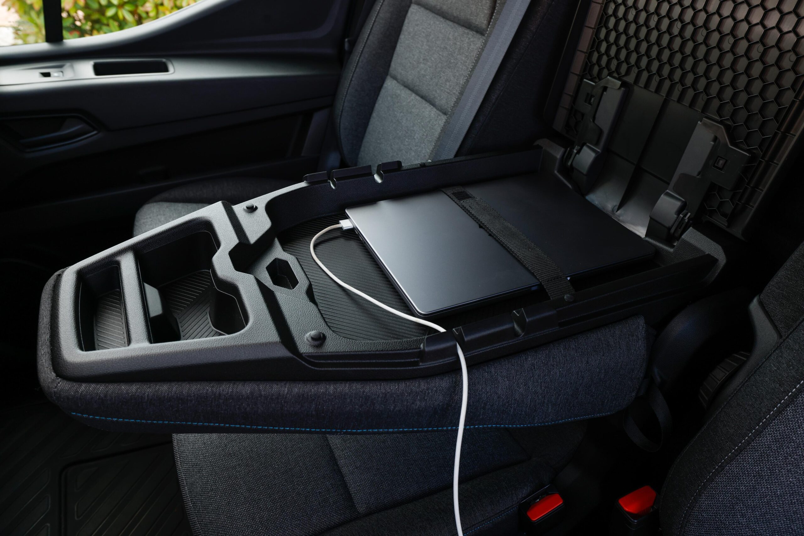 En la consola central abierta de un Renault Master, reposa una computadora portátil, perfectamente conectada a un cargador: una ecuación perfecta para los viajeros amantes de la tecnología.