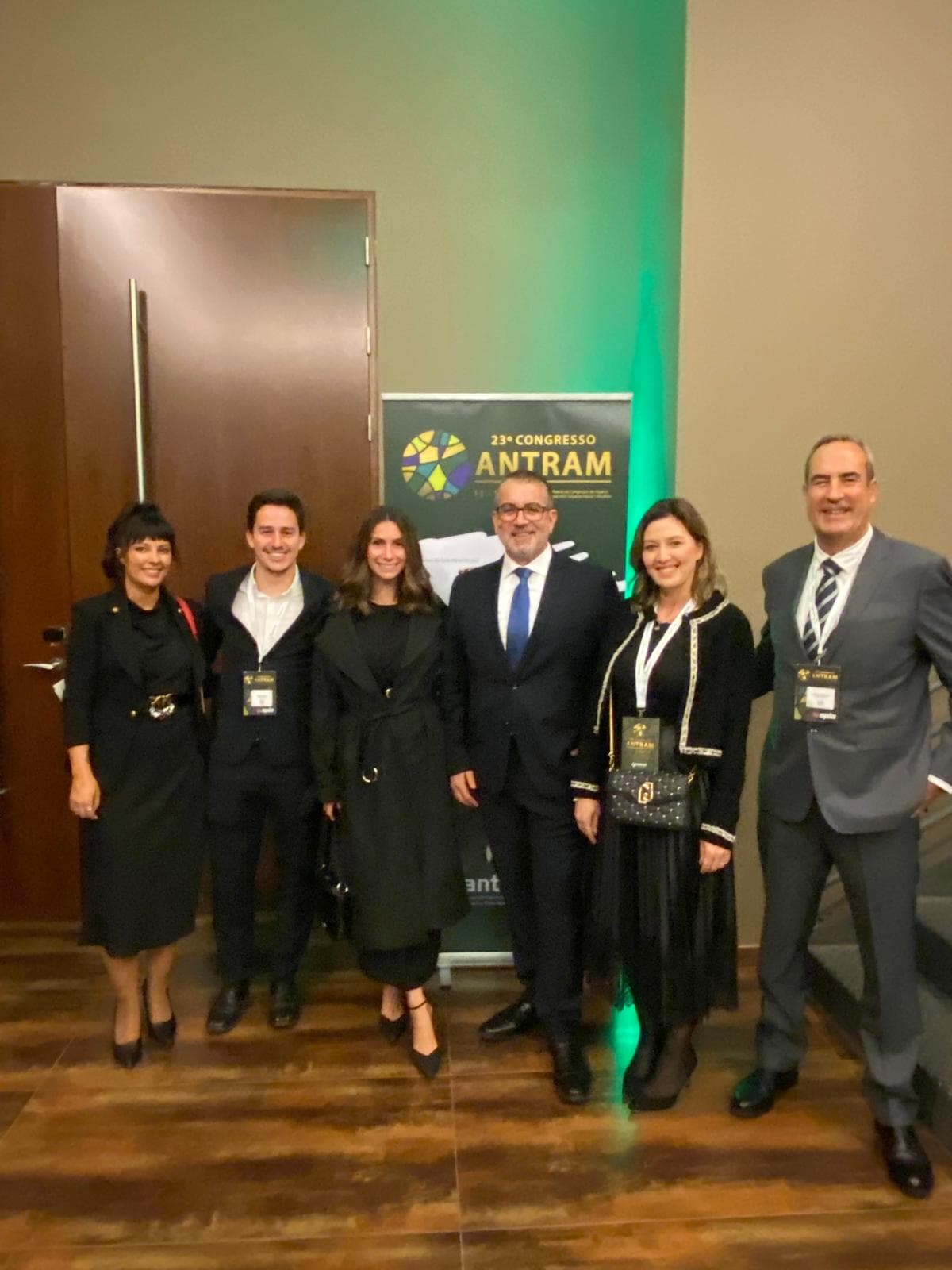 Un grupo de personas vestidas de gala, sonriendo cálidamente en el 23º Congreso de ANTRAM, destaca el compromiso de Andamur en ampliar servicios como el Área de Servicio San Román II.
