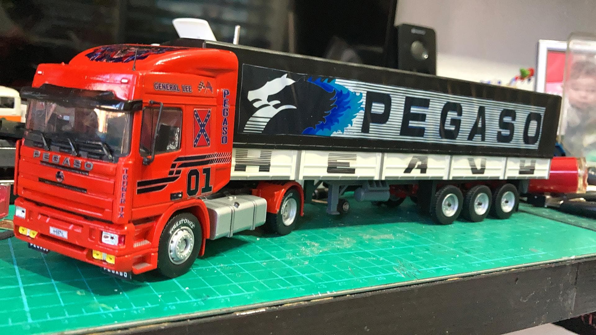 El camión modelo rojo y negro con el logo “Pegaso” en el remolque reposa sobre una alfombra de corte verde, que recuerda los viajes conquistados por Antonio Fernández, quien sorteó hábilmente los obstáculos a lo largo de su camino.