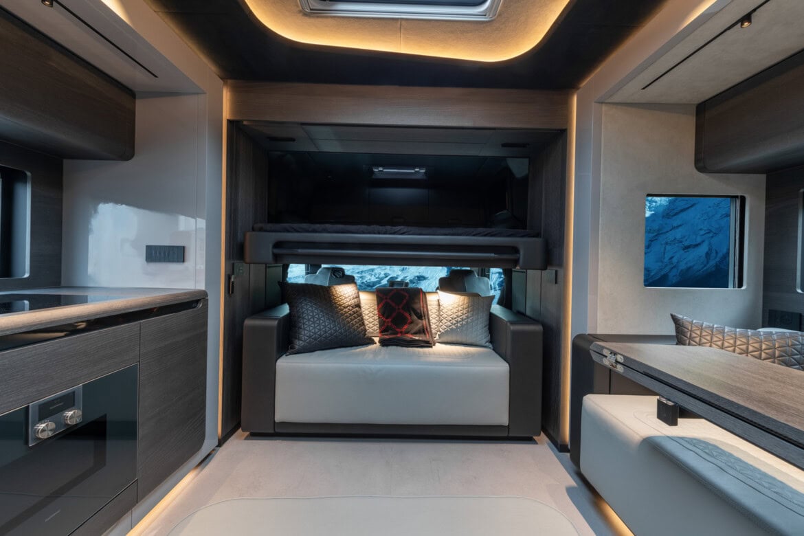 Experimente el lujo exquisito del interior de una autocaravana diseñada por Brabus, que combina a la perfección la estética moderna con una comodidad incomparable. Con una elegante litera, un lujoso sofá y una iluminación ambiental fascinante, esta autocaravana combina la sofisticación con la libertad de la carretera.
