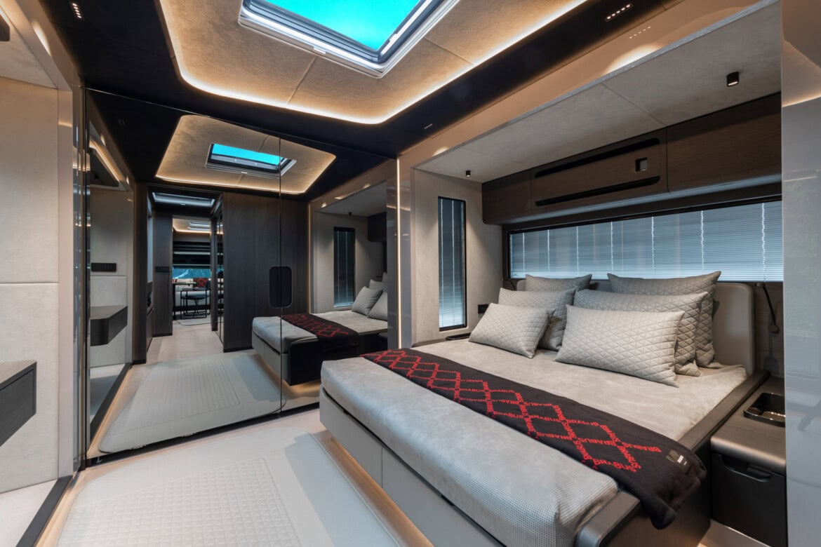 Interior lujoso de autocaravana con una cama cómoda y prolija, espejos e iluminación suave. El diseño extravagante ofrece un atractivo moderno y espacioso similar al del Brabus Big Boy 1200.