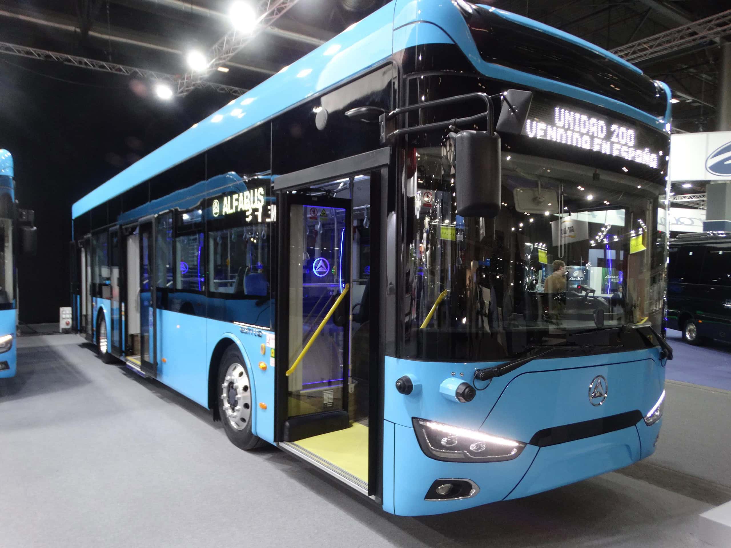 Un autobús urbano eléctrico azul con las puertas abiertas da la bienvenida a los visitantes de la Feria Internacional de Autobús, mostrando tecnología punta y confort para todos.