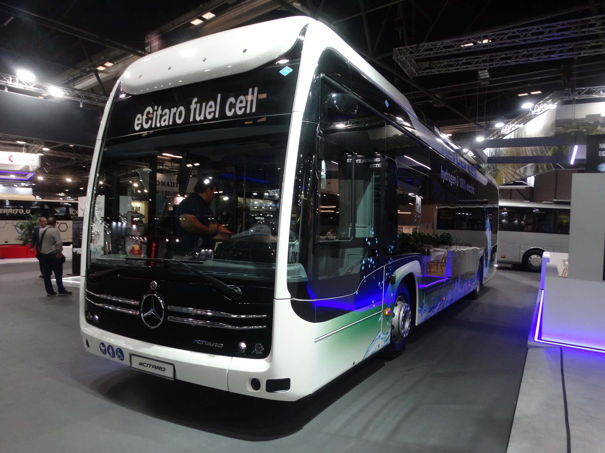 En la Feria Internacional del Autobús y del Autocar, un autobús de celda de combustible eCitaro blanco se exhibe en el interior, captando la atención de numerosos visitantes mientras crecía el interés por la tecnología sostenible.