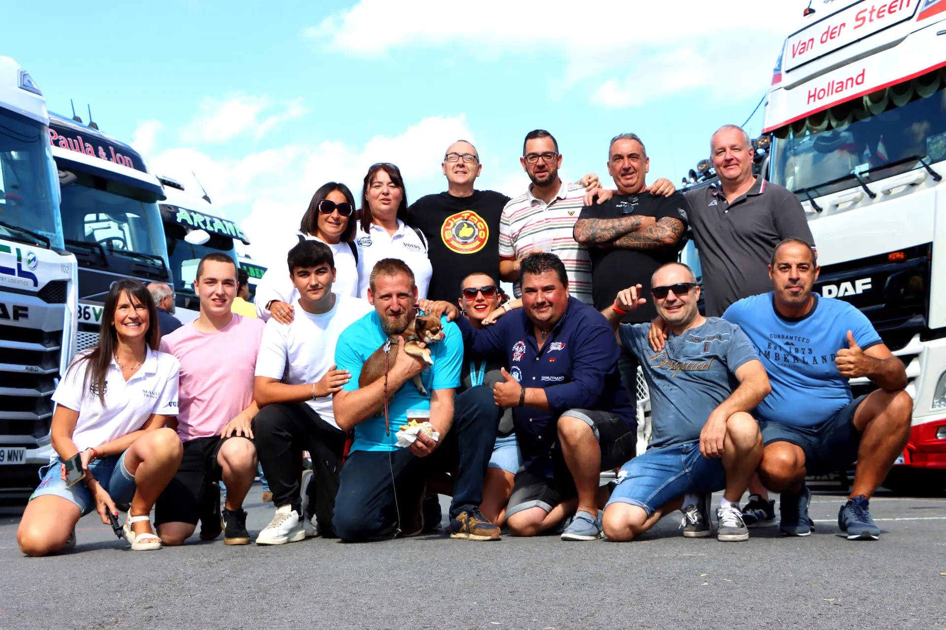 Un grupo de personas posando juntas delante de camiones en el Festival de Camiones de Barakaldo, sonriendo y levantando los pulgares.
