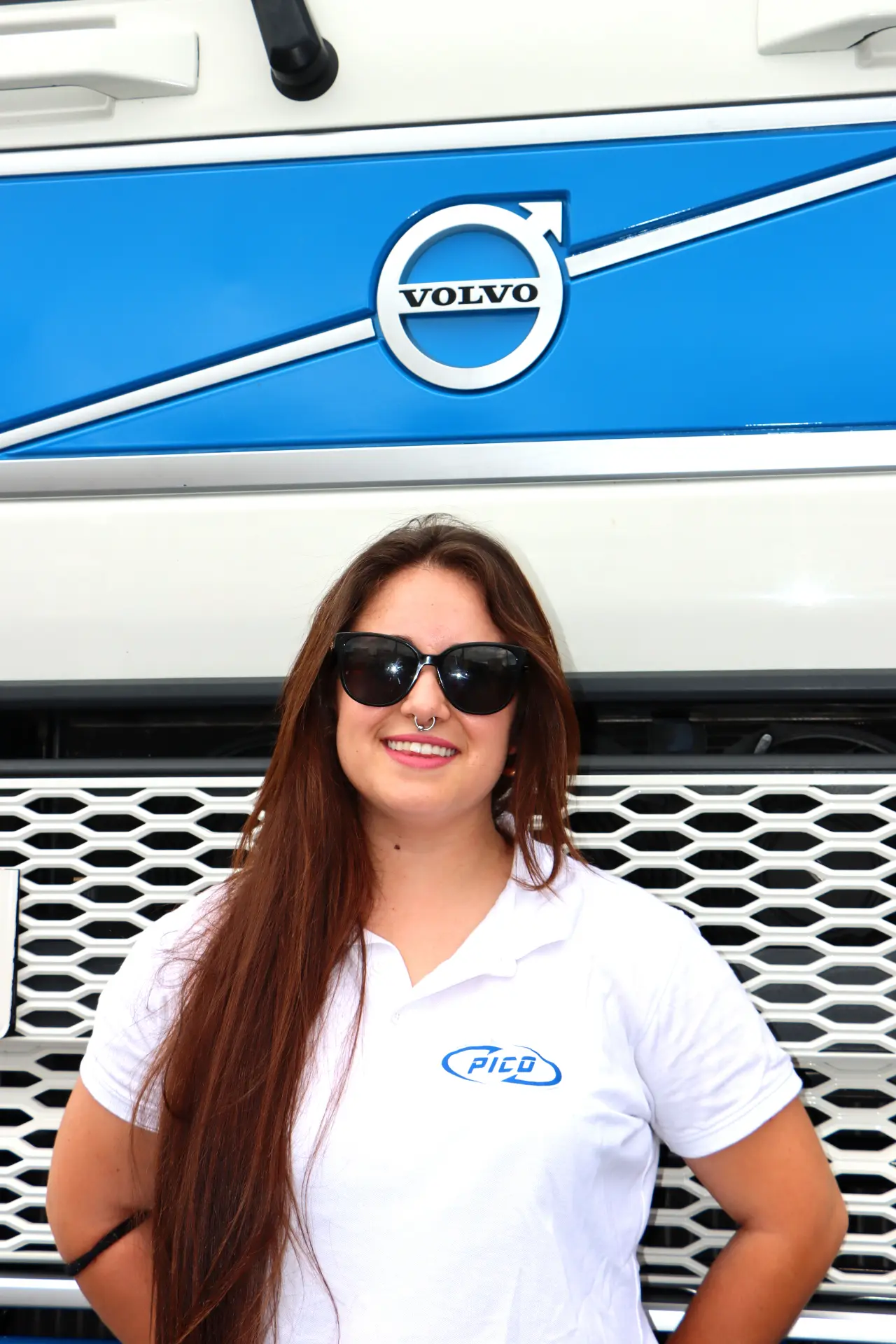 Persona con pelo largo y gafas de sol sonriendo delante de un camión Volvo en el Festival de Camiones de Barakaldo.