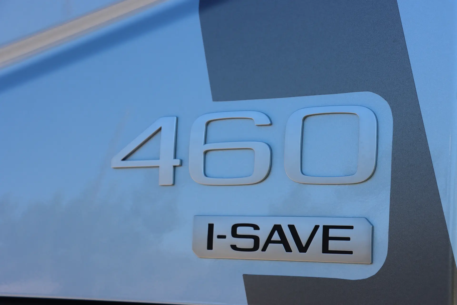 Primer plano de un elegante vehículo Volvo FH con el texto "Aero 460" y "I-SAVE" en su exterior, mostrando un diseño de fuente moderno.