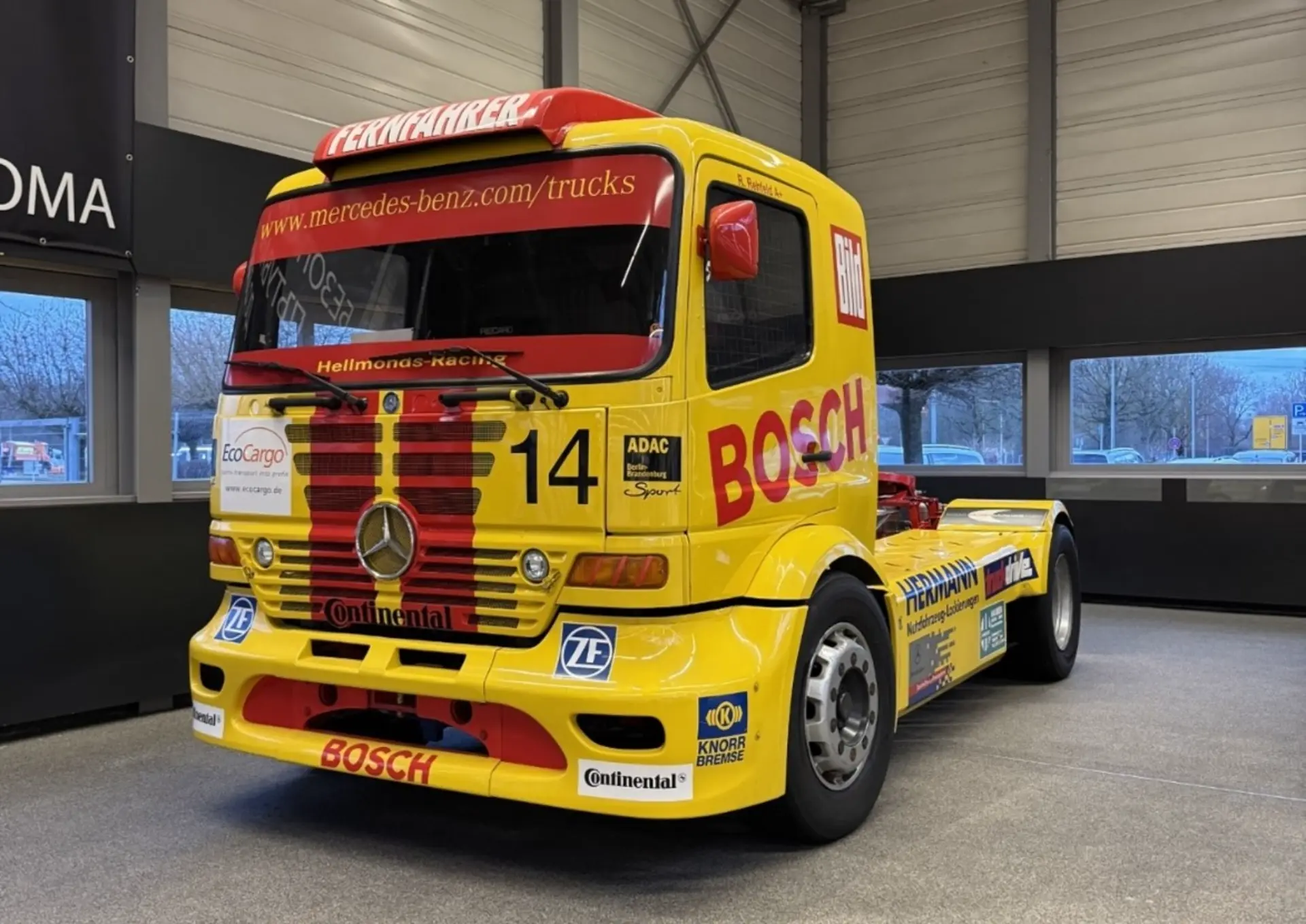 El camión de carreras amarillo, que se exhibe en el interior, ostenta las marcas "BOSCH" y "14". Su elegante diseño se ve acentuado por una serie de características avanzadas similares a las de un borrador automático, listo para arrasar con la competencia en cualquier pista.