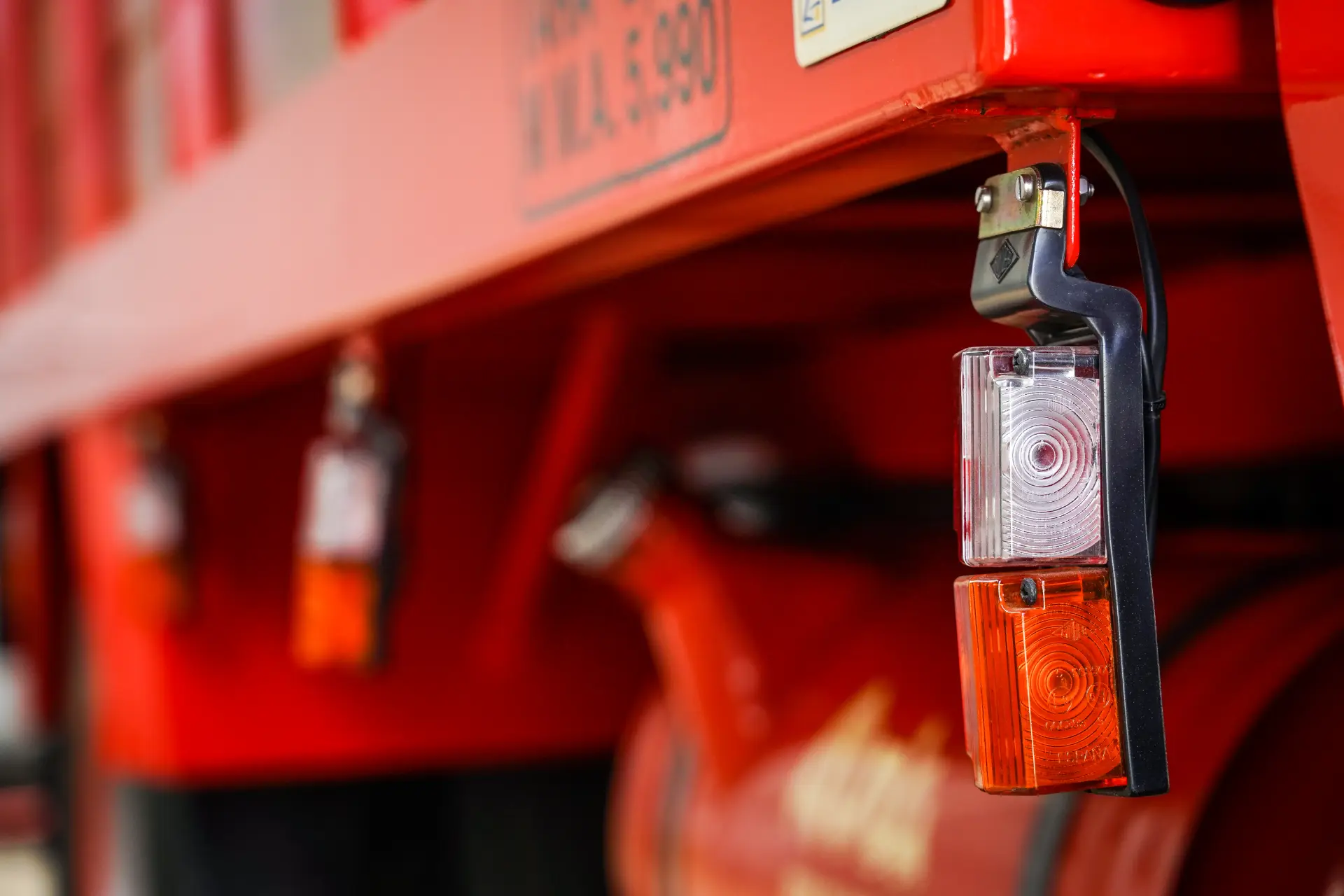 Primer plano de un Avia 3500 rojo bellamente restaurado, que muestra sus luces traseras con llamativas lentes rojas y blancas: un testimonio de la rica historia del Avia 3500.