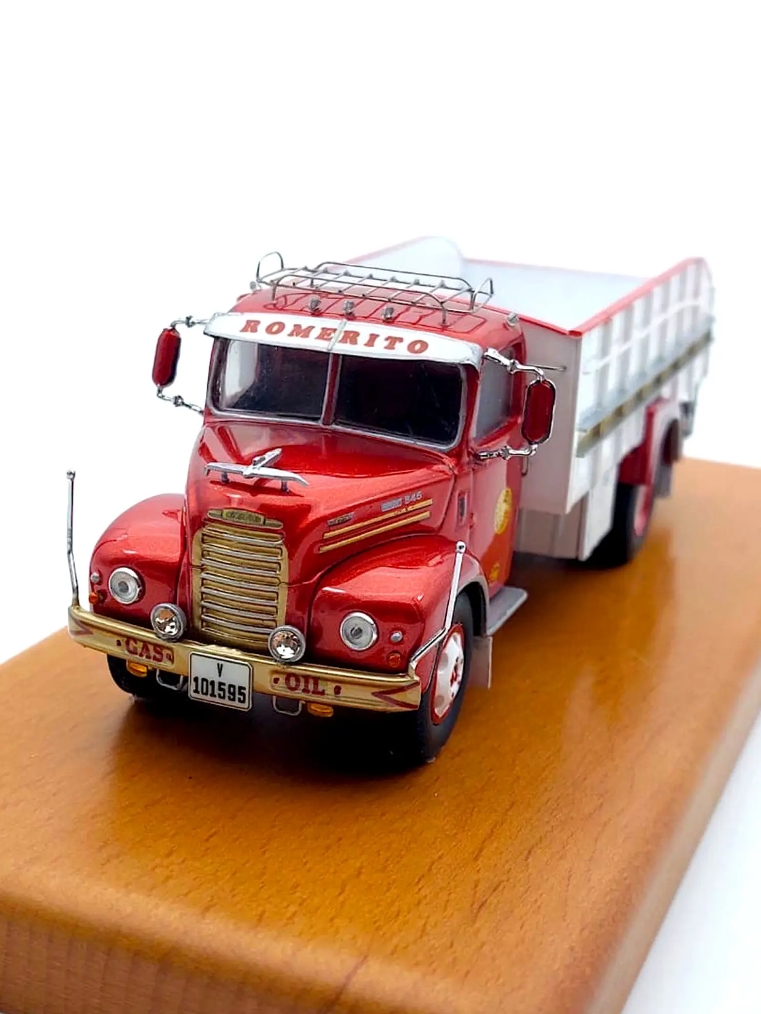 Modelo de camión de juguete vintage rojo y blanco con la etiqueta "ROMERITO" sobre una base de exhibición de madera, perfecto para los fanáticos del modelismo de camiones o quienes buscan inspiración sobre cómo hacer maquetas de camiones.