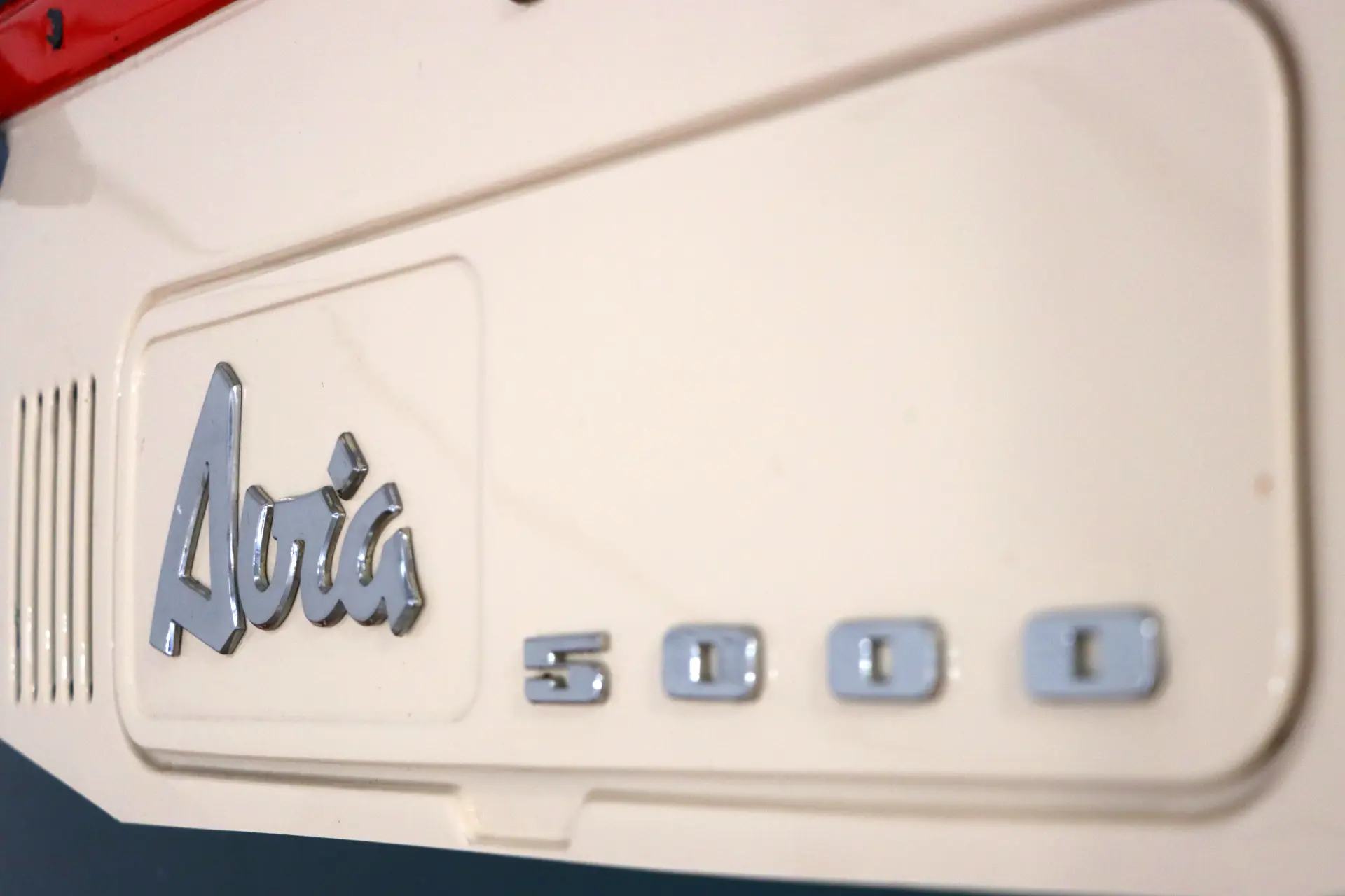 Primer plano de un panel de color crema con letras metálicas "Avia 5000", que resalta el legado de este camión familiar.