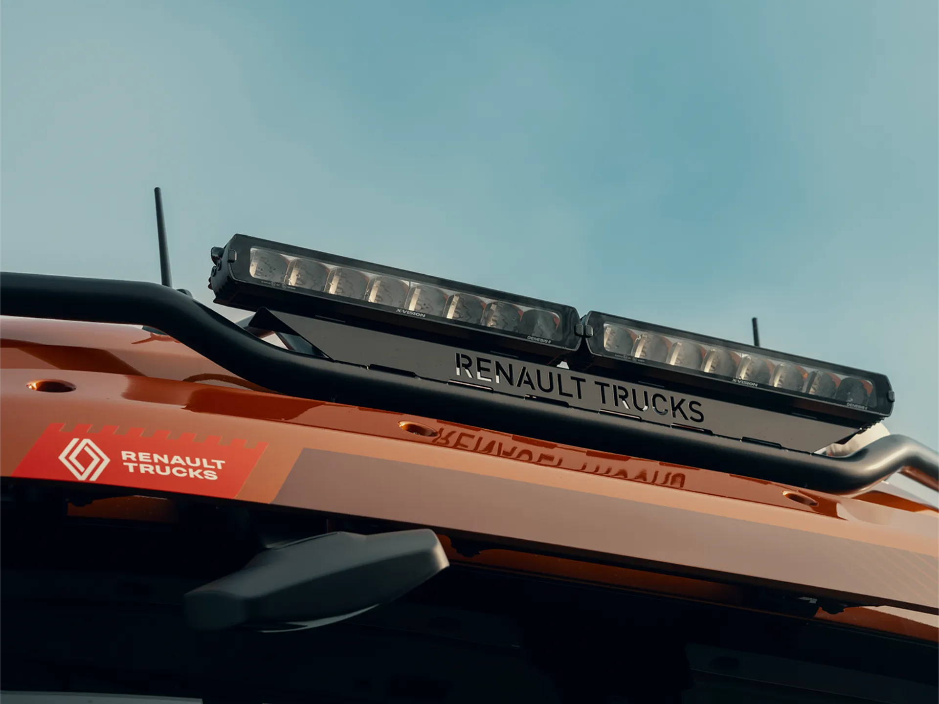 Primer plano del techo de un vehículo Renault Trucks con barras de luces LED, una pegatina con el logotipo de Renault Trucks y un borrador automático montado de forma segura en el interior.
