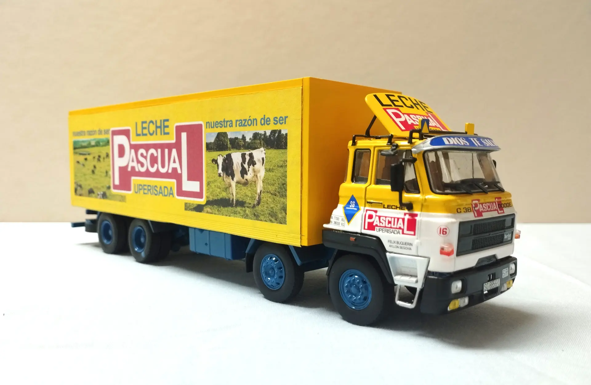 Camión de juguete amarillo con imágenes de "Leche Pascual" y vacas en su costado, exhibido sobre una superficie blanca, perfecto para coleccionistas de maquetas de camiones o fanáticos de los camiones a escala 1:43.