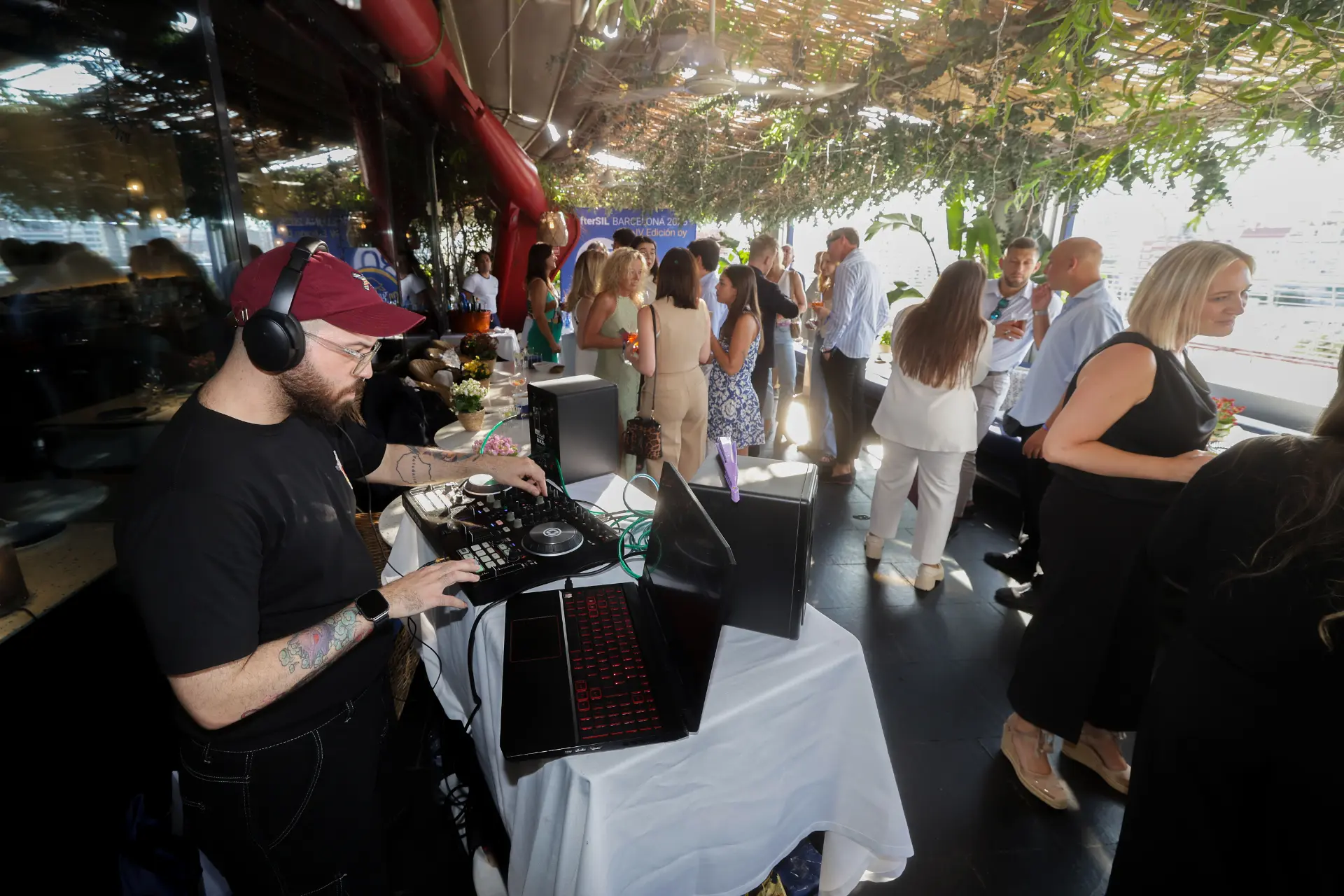 Un DJ pincha música en un evento al aire libre organizado por OnTurtle, líder en transporte, donde la gente se mezcla y disfruta de los mejores servicios para transportistas.
