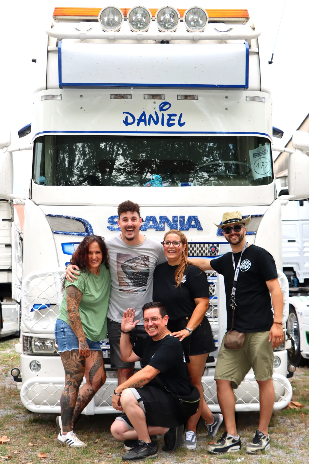 Cinco personas sonrientes posan delante de un gran camión blanco con "Daniel" sobre el parabrisas en la XI Concentración de camiones de Olot.
