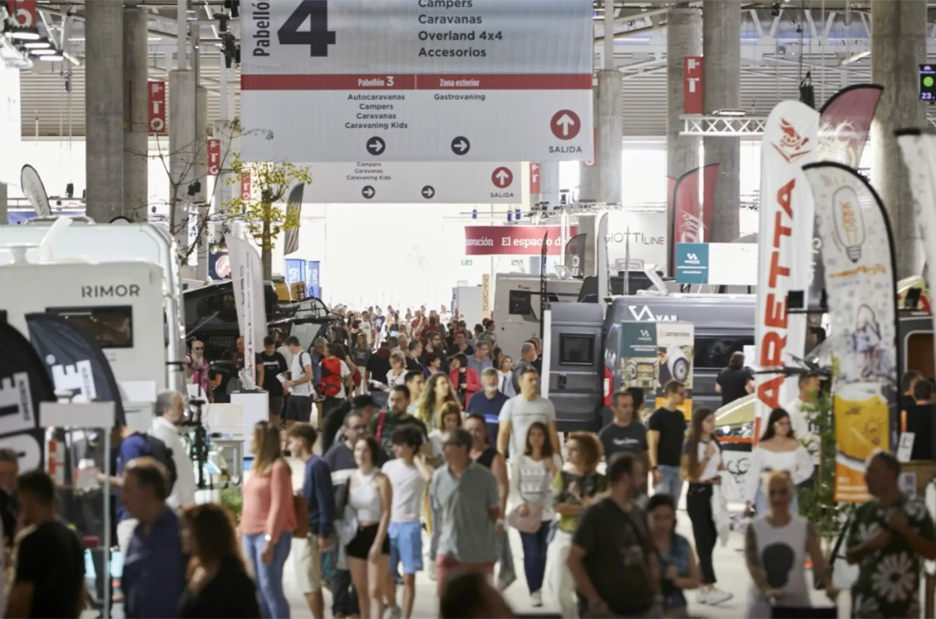 Una gran multitud recorre la exposición cubierta Salón Caravaning Barcelona 2025, explorando las autocaravanas y campers expuestas.