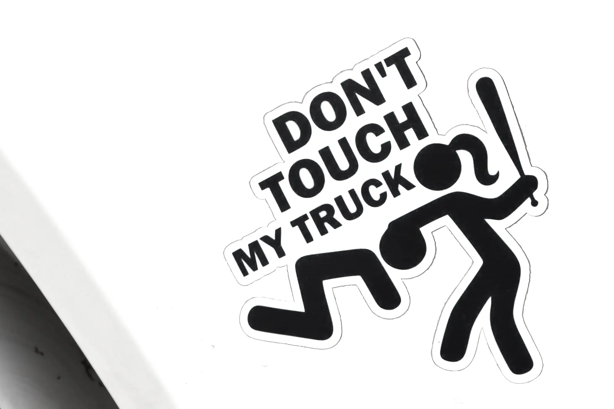 Adhesivo que muestra "NO TOQUES MI CAMIÓN" con una figura de palo golpeando a otra con un bate, diseñado en un atrevido estilo Borrador automático sobre fondo blanco.