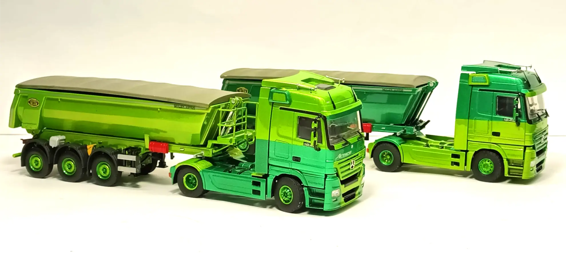 Sobre un fondo blanco liso se muestran dos brillantes modelos de semirremolques verdes con remolque, perfectos para coleccionismo de camiones o como inspiración para quienes buscan cómo hacer una maqueta de camión.