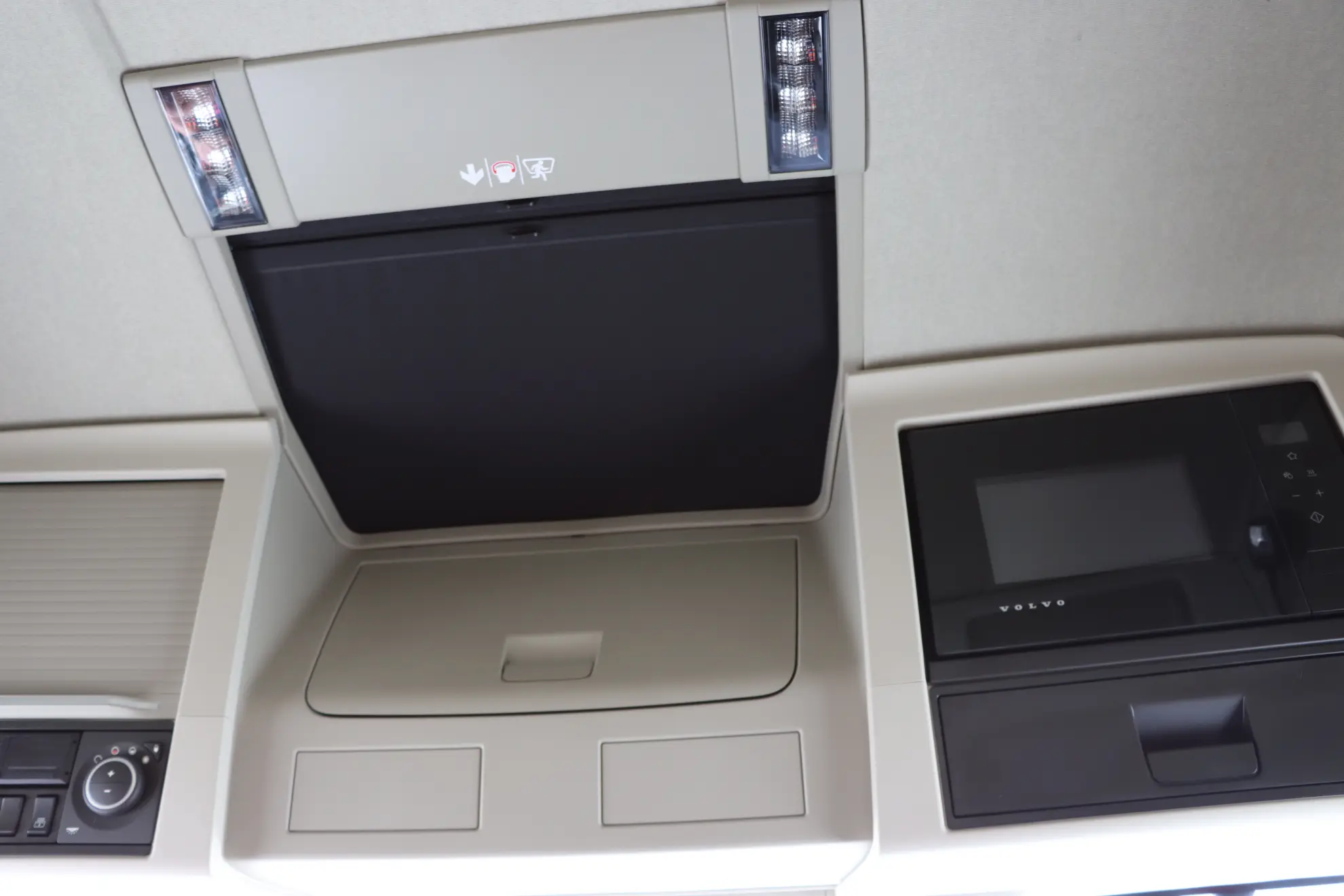 Consola superior en la cabina de un vehículo con compartimentos de almacenamiento y paneles de control, ideal para flotas modernas como Volvo a gas, donde la disposición eficiente favorece tanto la comodidad como la gestión del gas tco camión.