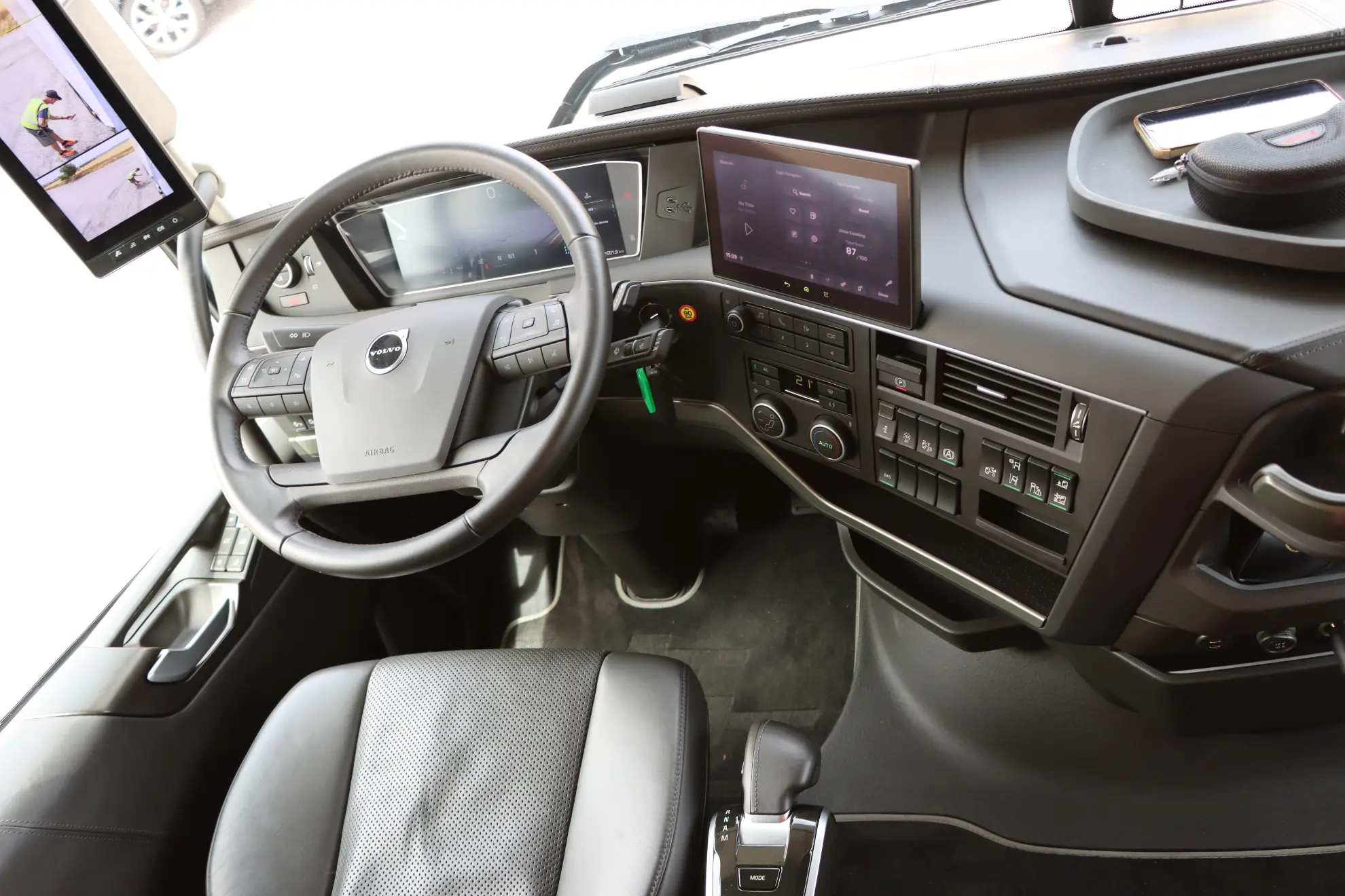 Moderno interior de la cabina del camión con volante, pantallas digitales y varios paneles de control, ideal para camiones a gas y una gestión eficiente de gestor de flotas.
