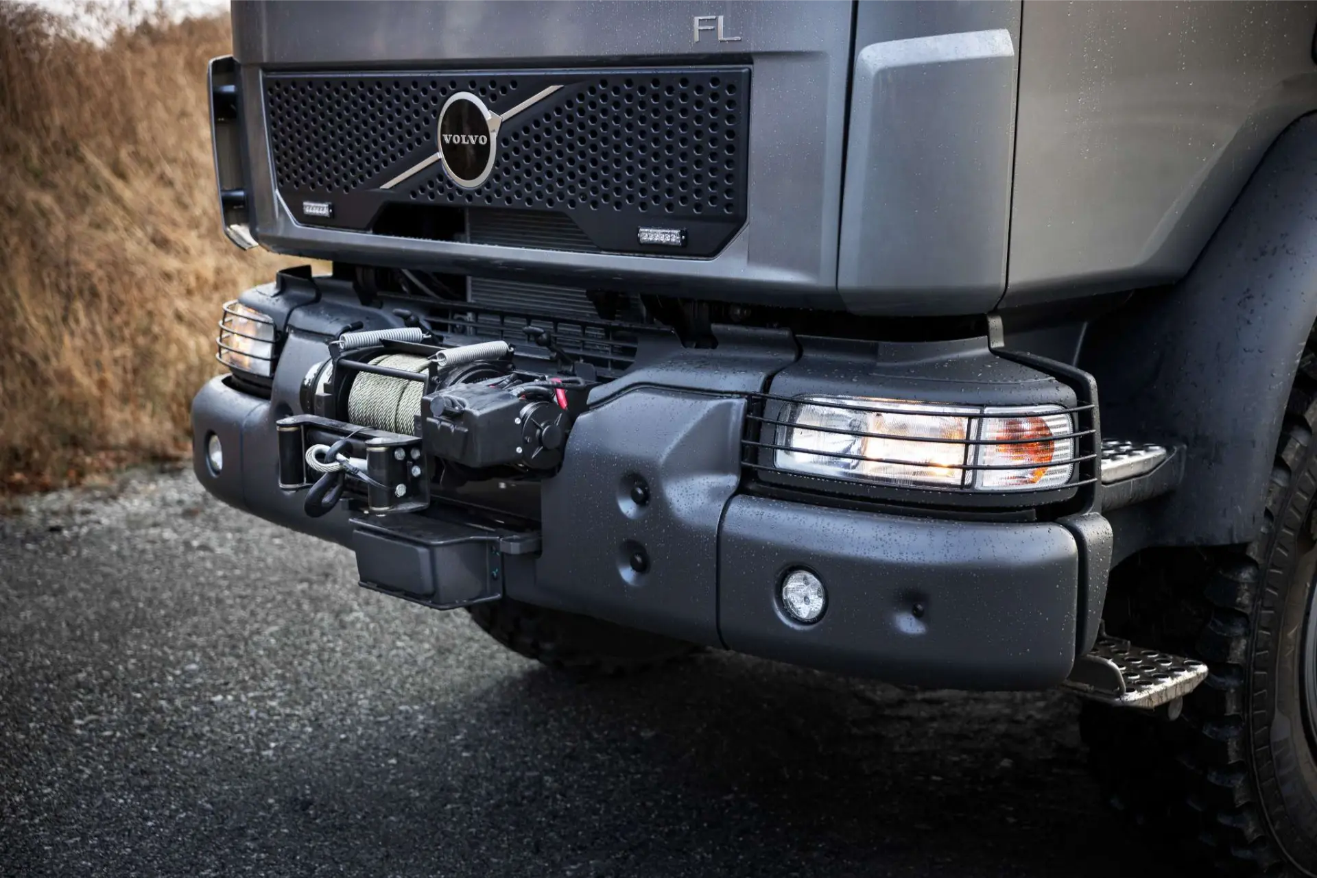 Primer plano del parachoques delantero de un camión Volvo FL con un cabrestante montado y faros visibles.