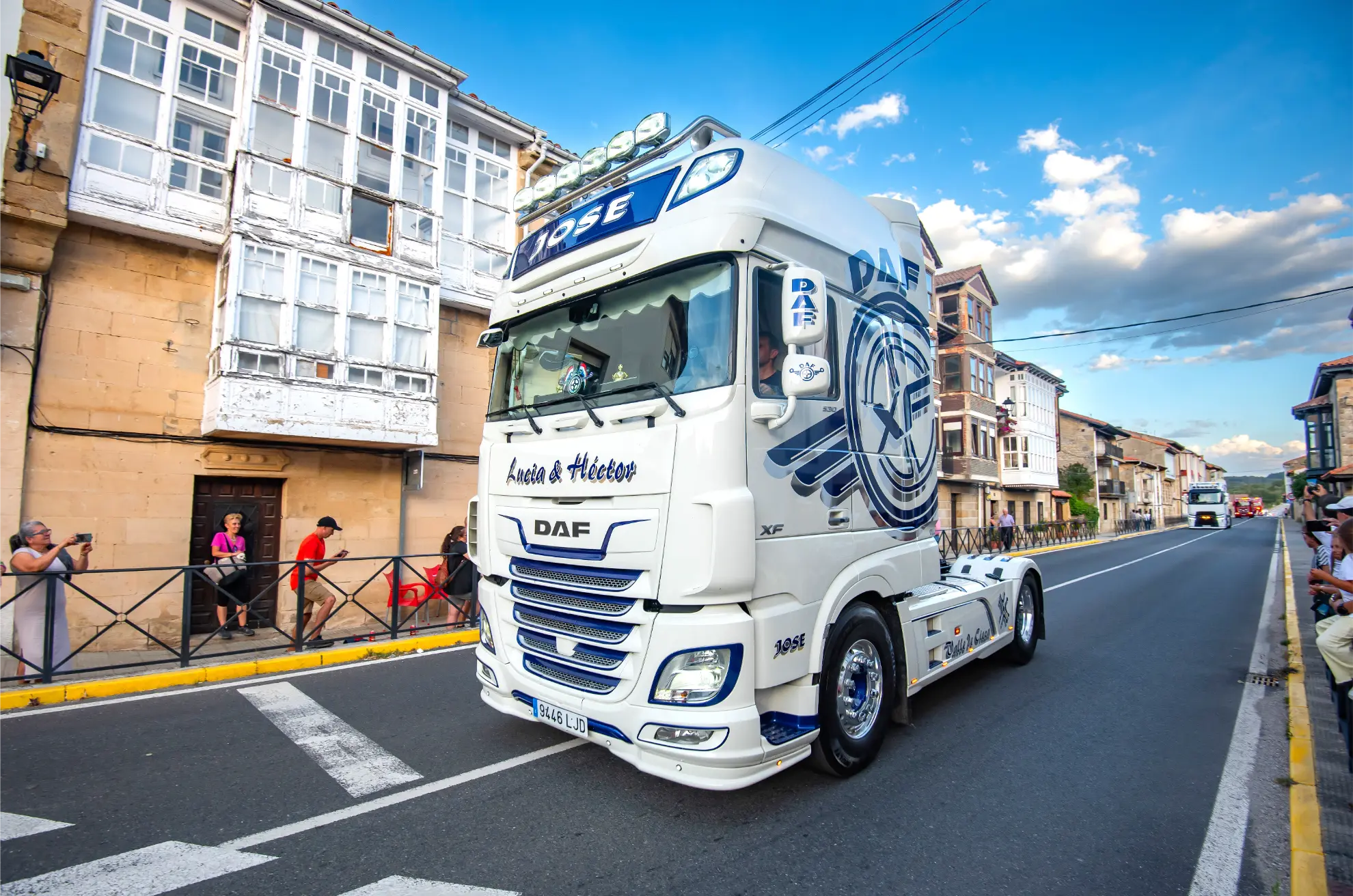 Un semirremolque DAF blanco con detalles azules atraviesa Soncillo 2025 durante la Quedada de Camiones, mientras la gente observa desde la acera, captando una escena memorable para cualquier crónica de eventos.