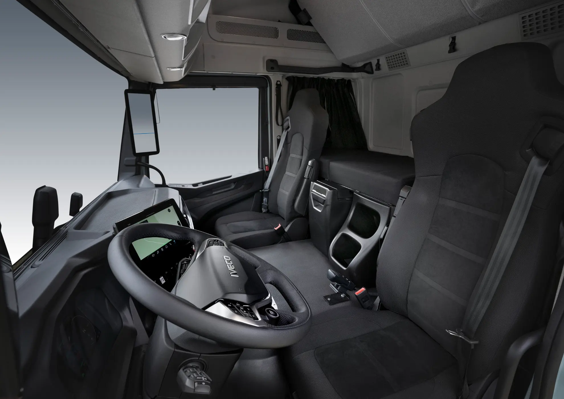 Interior de una moderna cabina de camión IVECO con dos asientos, volante y salpicadero, que muestra el confort y la innovación de los modelos S-eWay y Rígido.