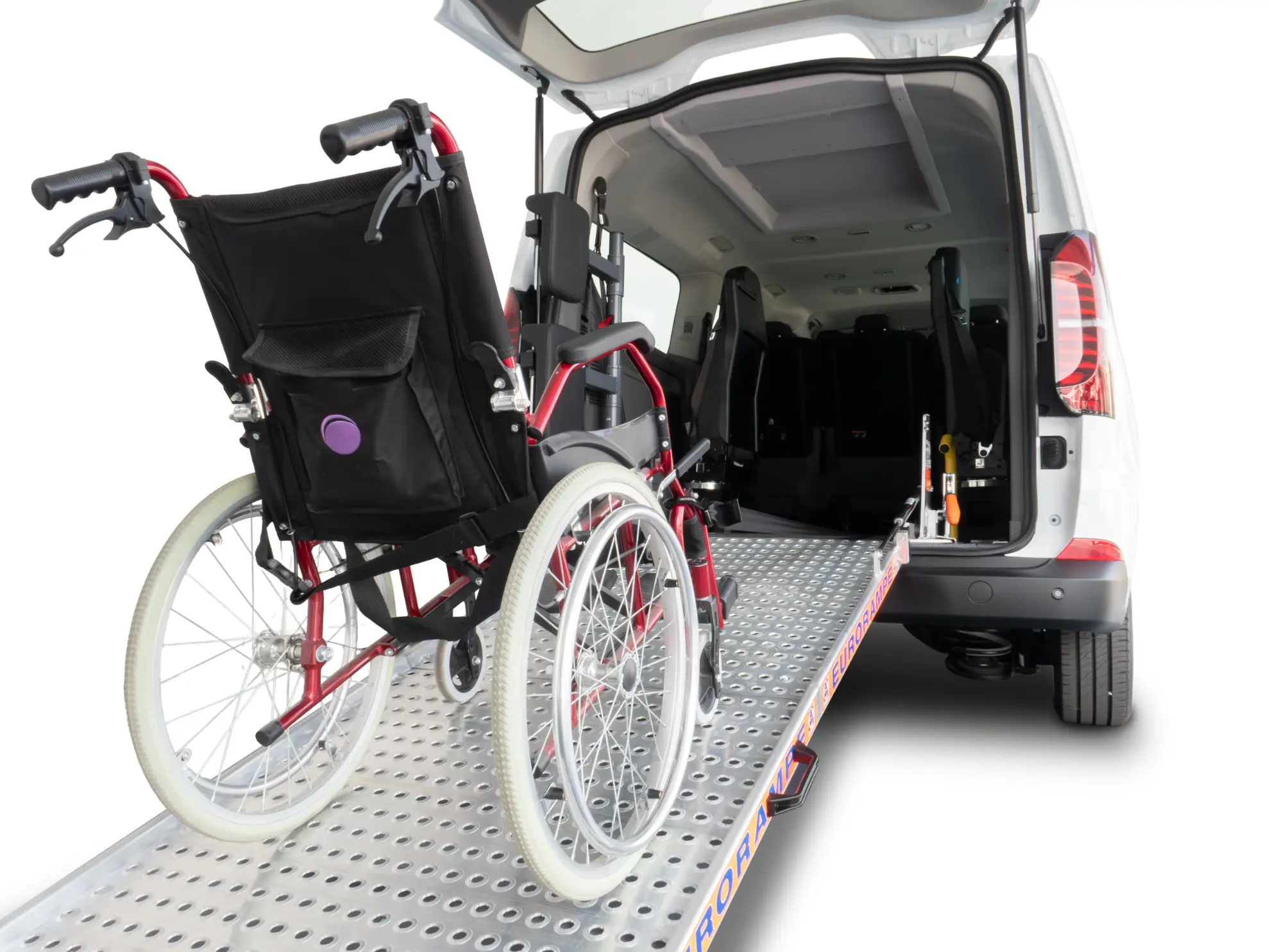 Se carga una silla de ruedas en rampa en la parte trasera de una furgoneta equipada con borrador automático y accesible para sillas de ruedas.