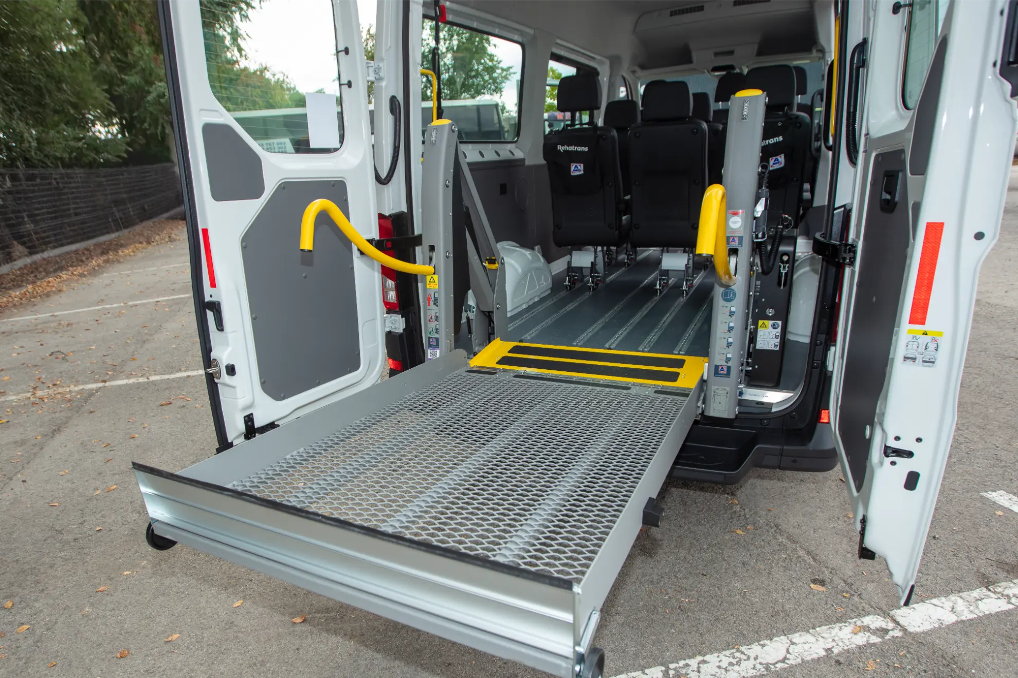 Una furgoneta MAN TGE carrozada con una rampa extendida para sillas de ruedas en la parte trasera, lista para el embarque accesible.