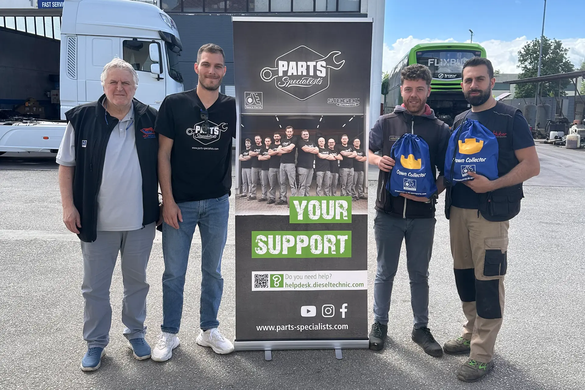 Cuatro hombres de pie junto a una pancarta y un camión de "Parts Specialists", dos de ellos con bolsas azules con la etiqueta "Trash Collector" (Recogedor de basura), muestran asesoramiento talleres camiones para mejorar rentabilidad taller camiones.