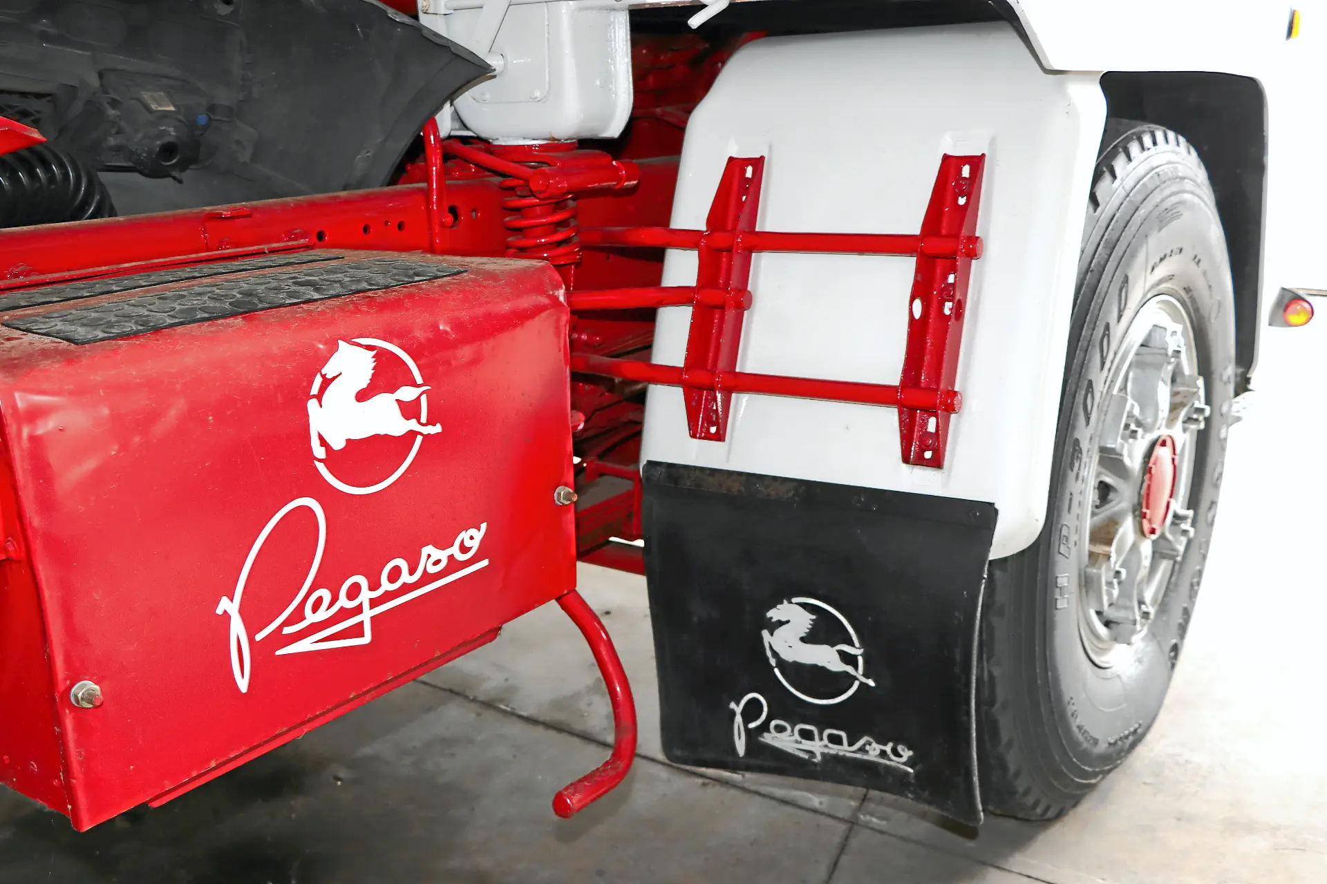 Detalle de una rueda de camión Pegaso, guardabarros, caja de herramientas roja y guardabarros con logotipos Pegaso, un detalle icónico para los aficionados a los camiones clásicos y Cresmotrans Náuticos & Especiales.
