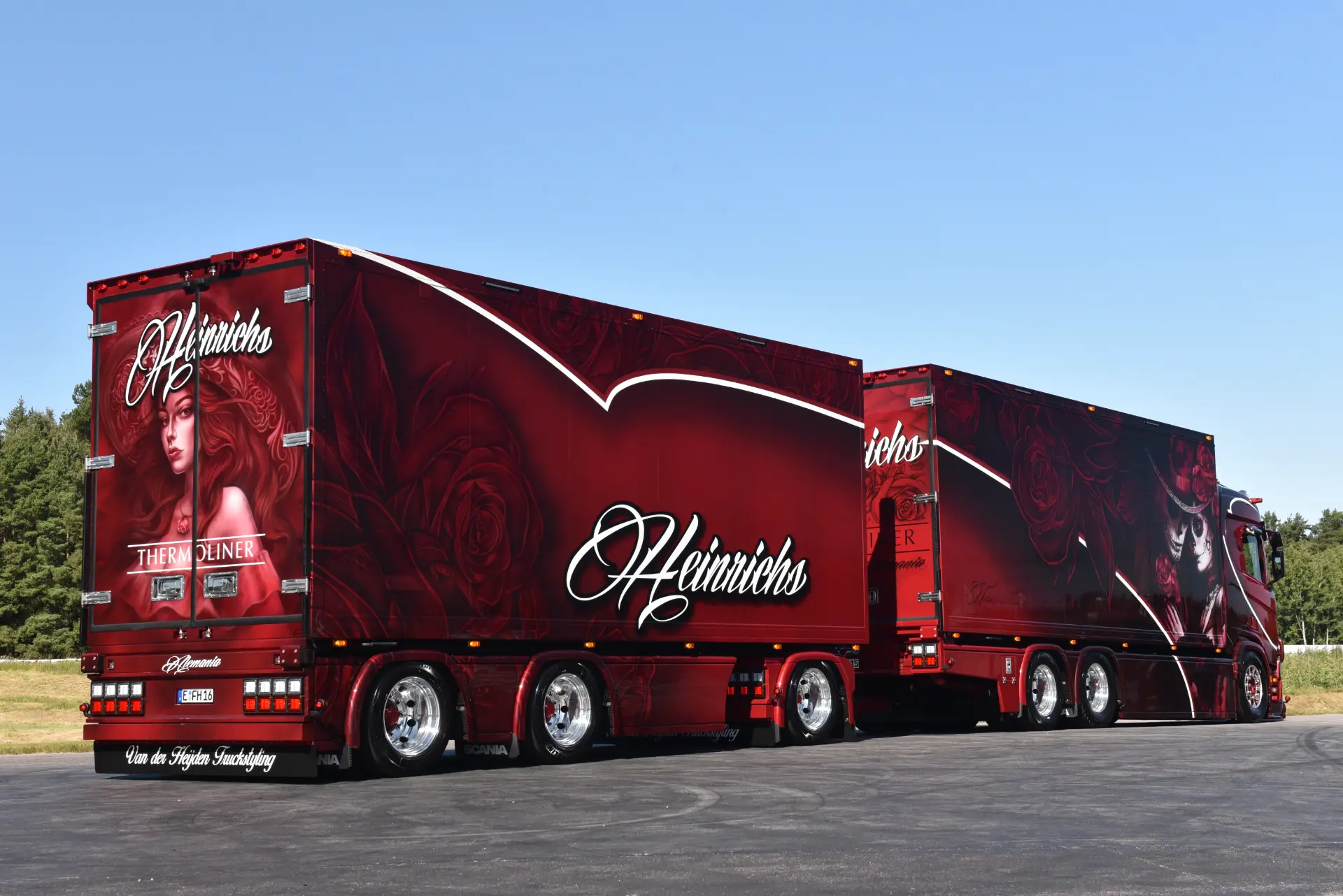Camión semirremolque rojo personalizado con elaboradas ilustraciones de rosas y mujeres, letras "Heinrichs" y un toque de estilo Borrador automático.