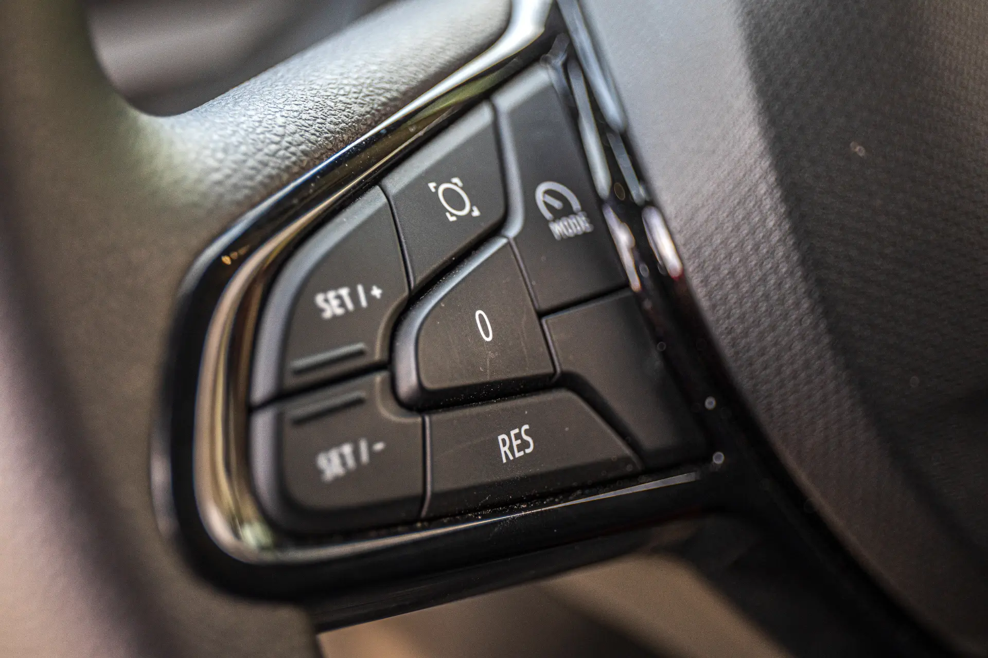 Detalle de los botones del volante del coche para el control de crucero y funciones relacionadas, como se ve en un furgón Renault Master.