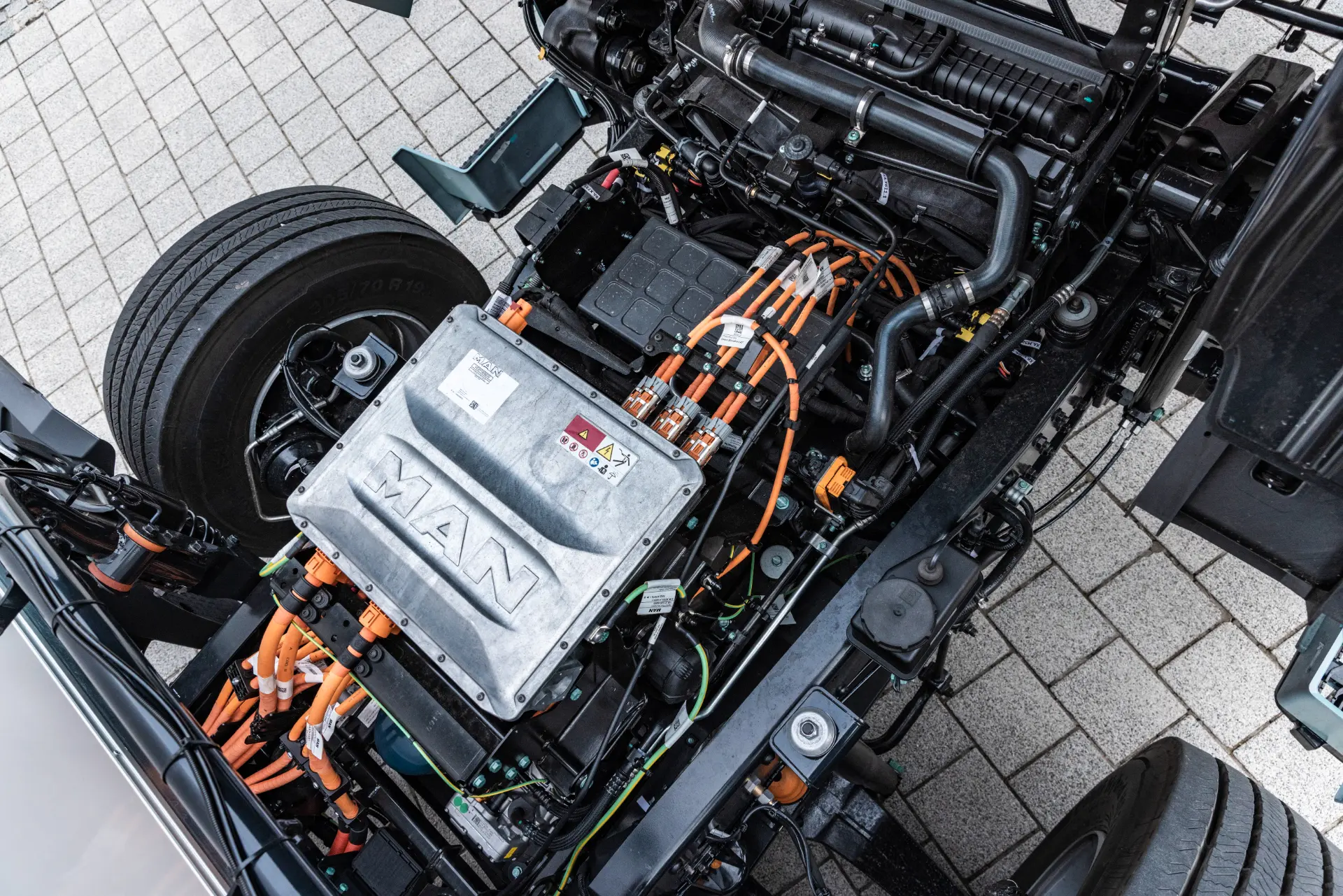 Un primer plano del motor y el cableado de un vehículo eléctrico, con la marca MAN y destacando su avanzado sistema de borrador automático.