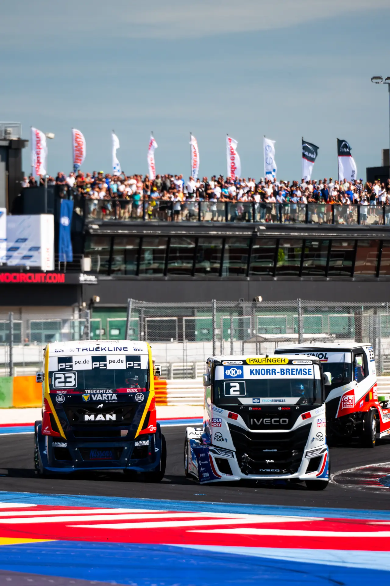 Dos camiones de carreras compiten en una colorida pista ante una gran multitud, mostrando la emoción del Goodyear FIA ETRC 2026.