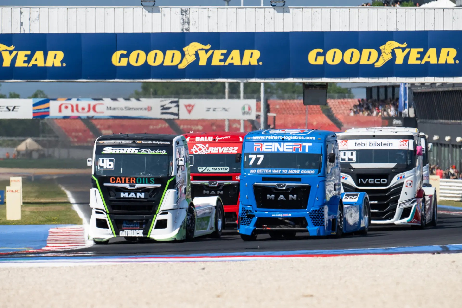 Cuatro camiones de carreras compiten en una pista bajo un puente Goodyear durante el emocionante Campeonato Europeo de Carreras de Camiones 2026 ETRC en Misano.