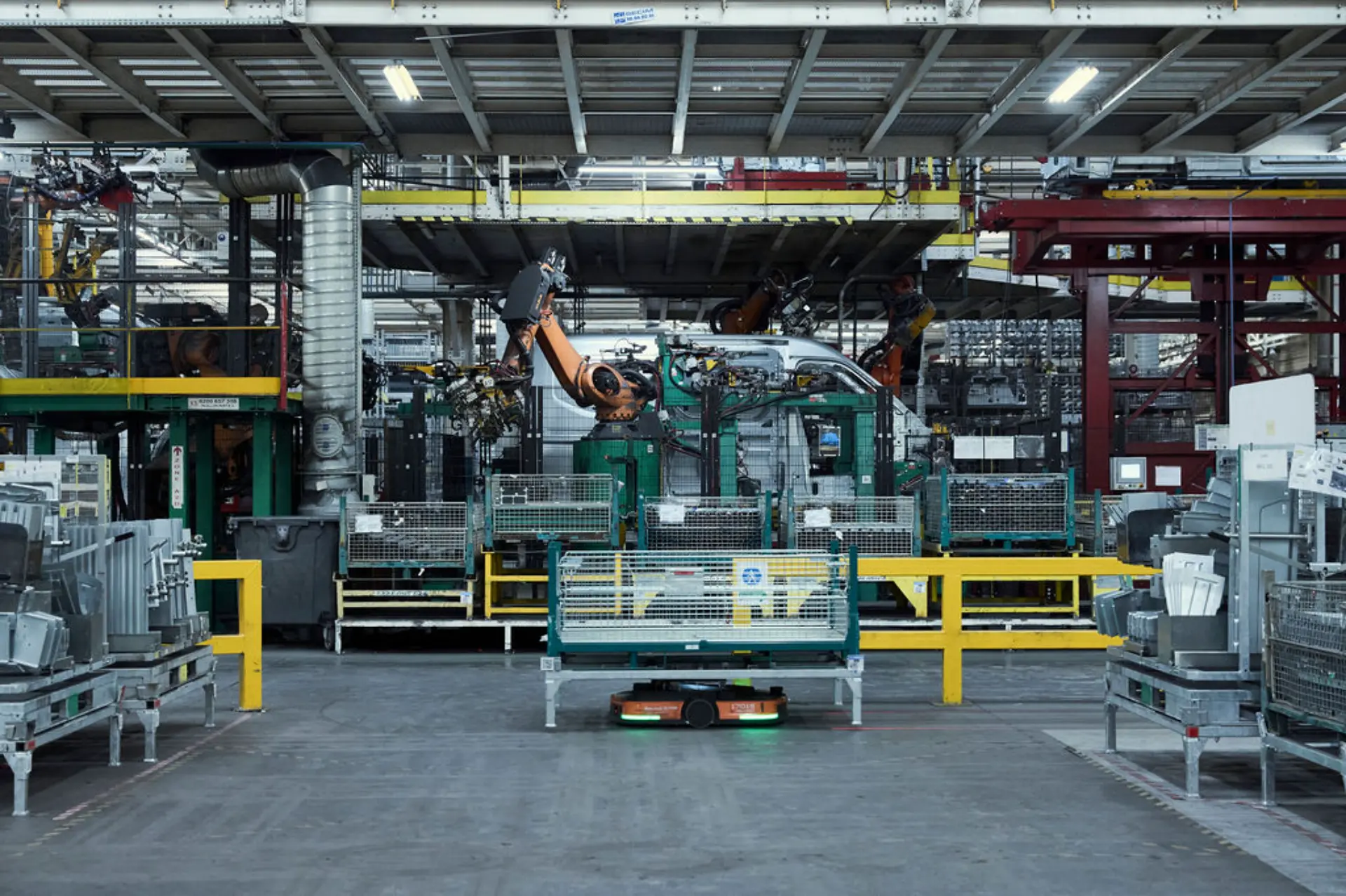 Planta de producción con brazos robóticos de Renault, maquinaria y barreras metálicas en un entorno industrial de Batilly.