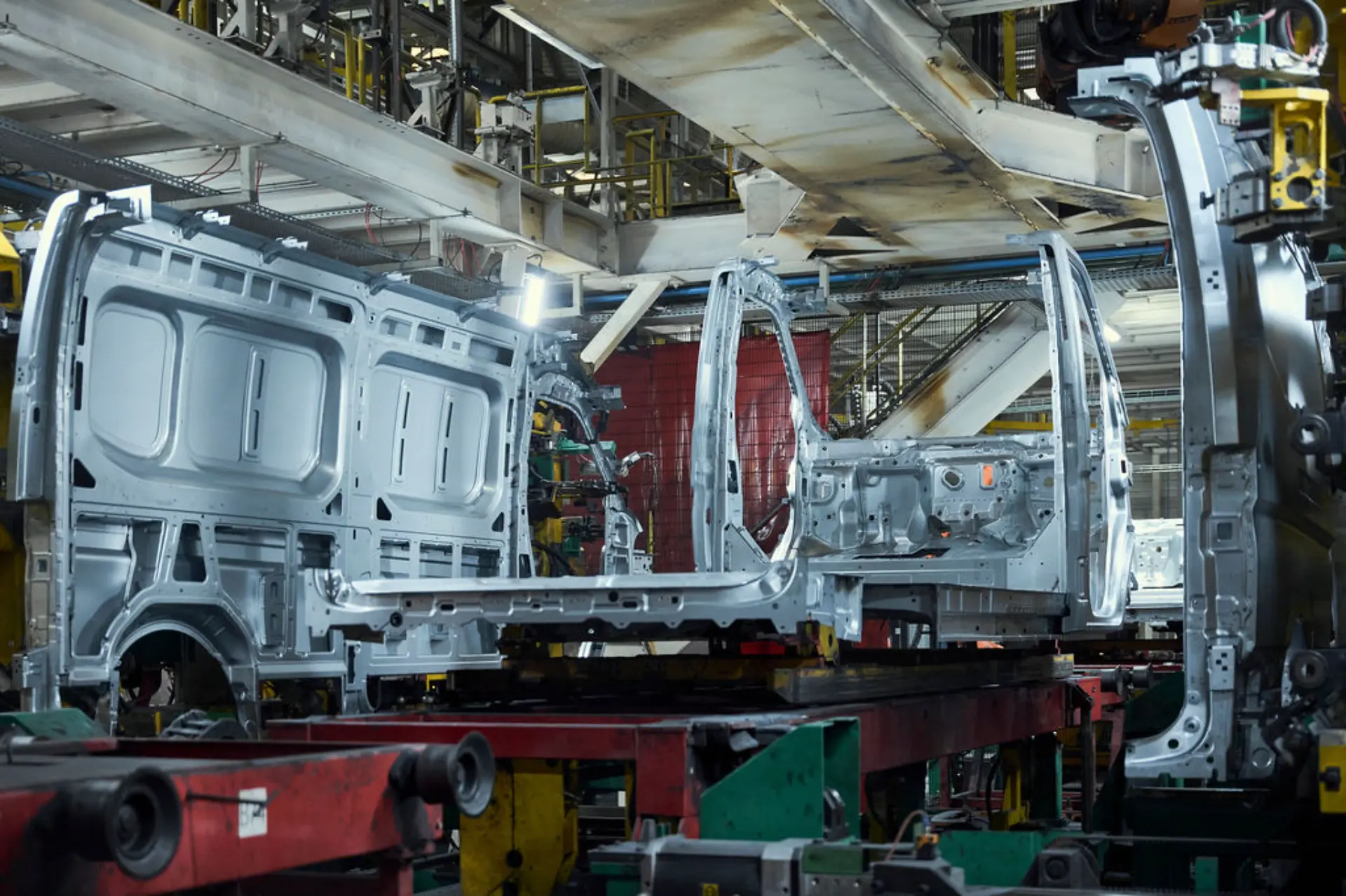 Carrocerías en una cadena de montaje de la fábrica de Renault en Batilly, con los modelos Master tomando forma entre la maquinaria industrial que se divisa al fondo.