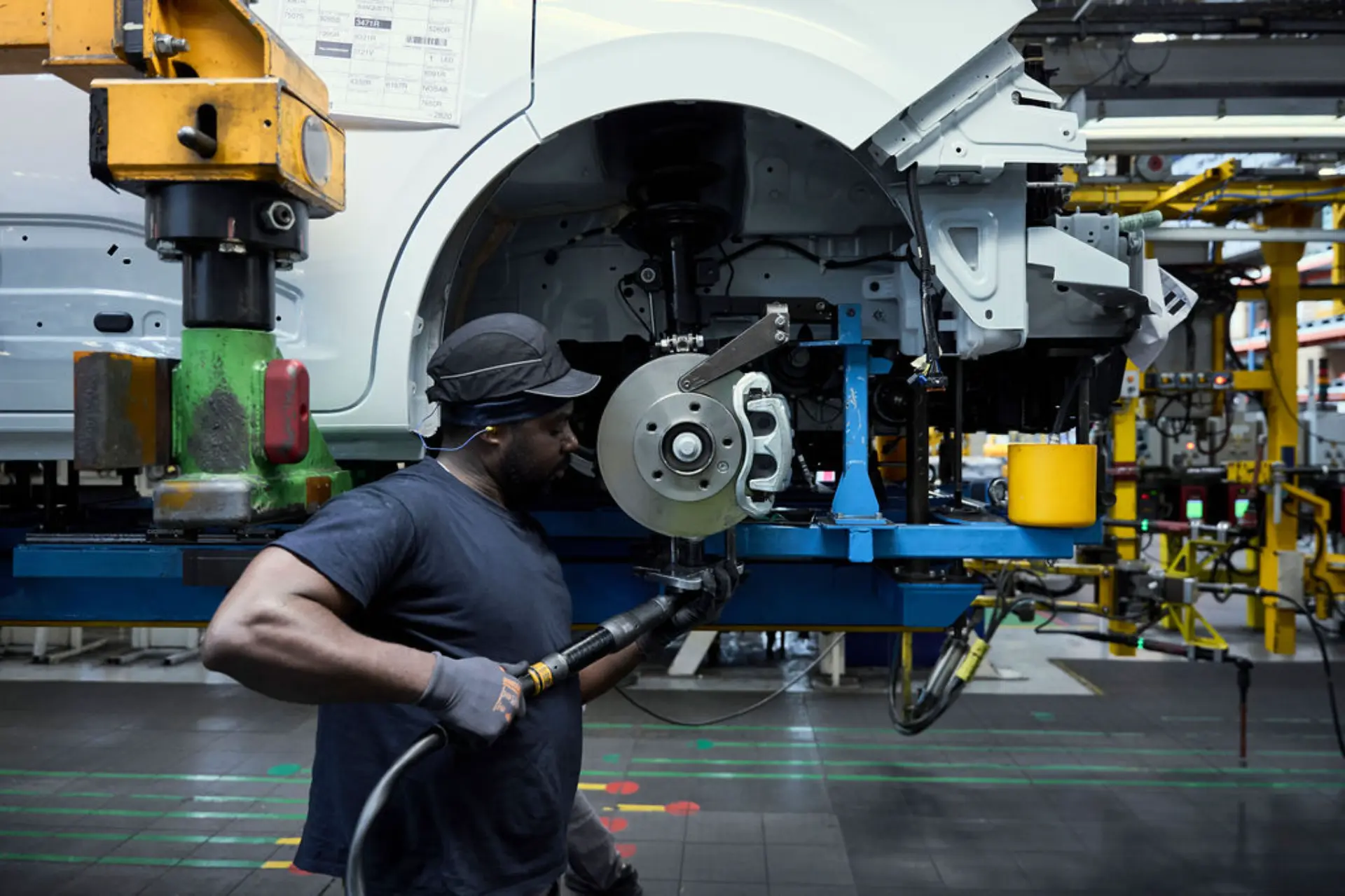 Un trabajador de fábrica utiliza una herramienta eléctrica para montar una Renault Master en la línea de producción de automóviles de Renault en Batilly, ofreciendo a los clientes profesionales un trabajo de gran precisión.