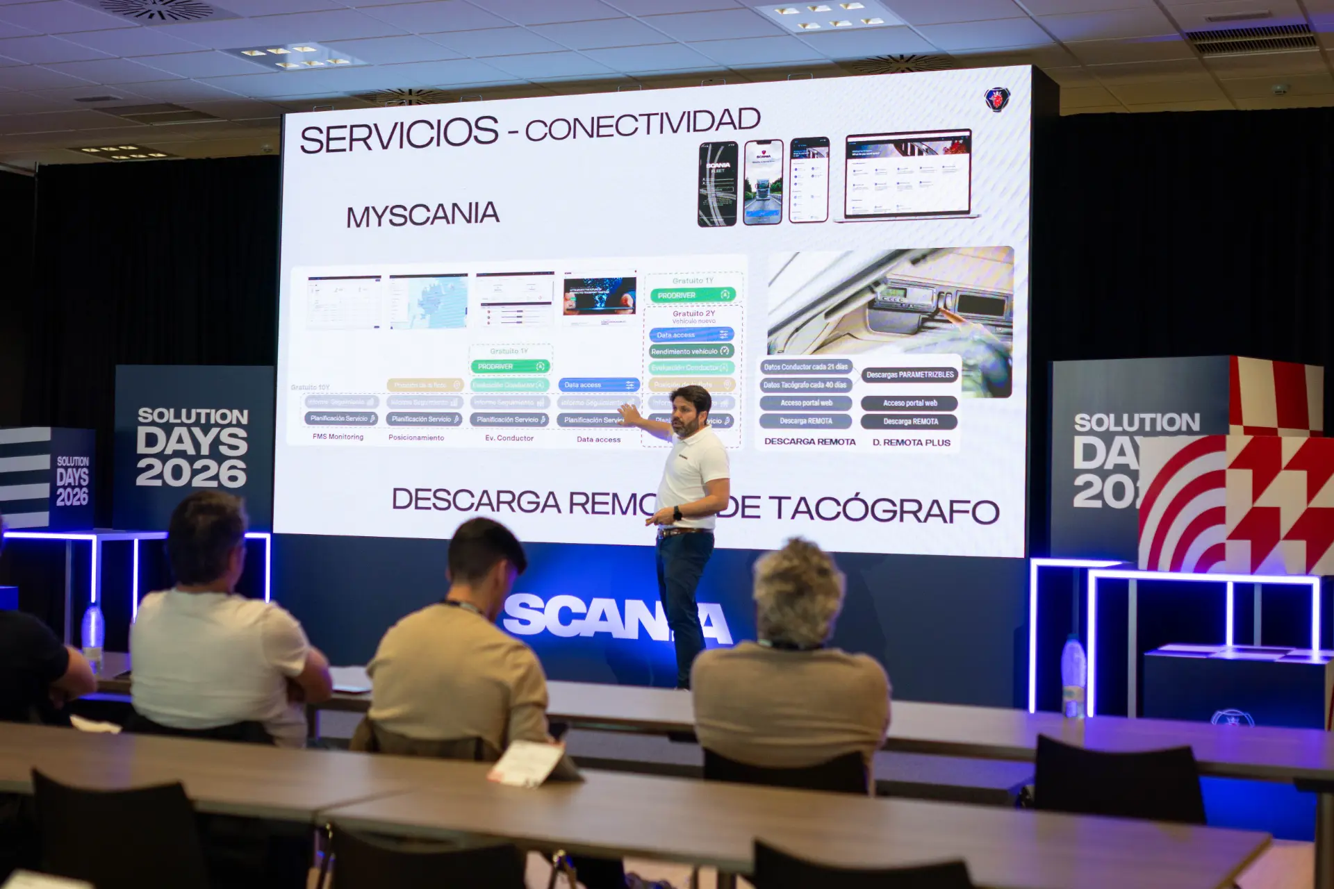 Un hombre ofrece una presentación sobre servicios y tecnología de conectividad, haciendo hincapié en las soluciones de Scania, ante el público asistente al evento «Scania Solution Days 2026».