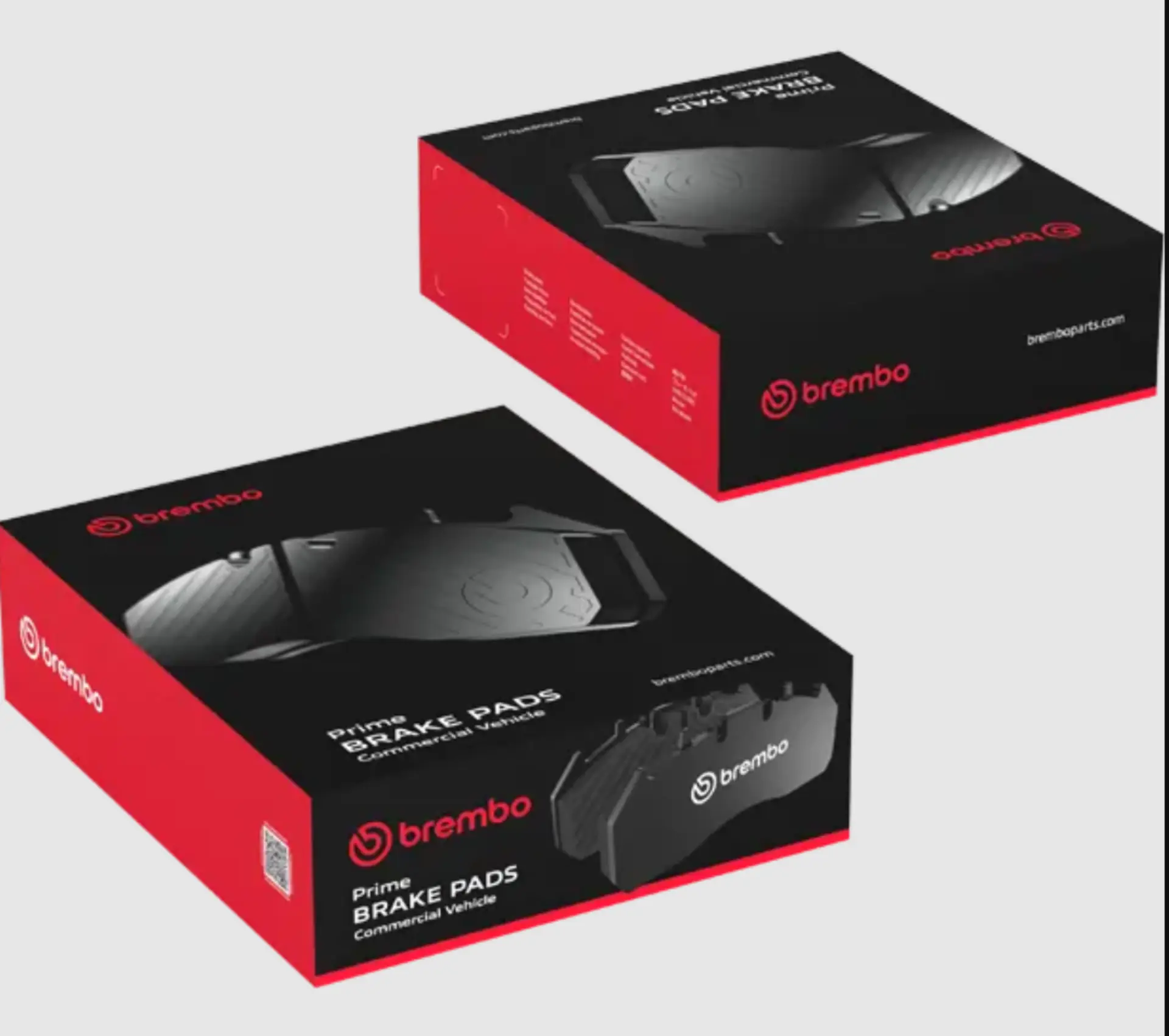 Dos cajas de pastillas de freno Brembo, rojas y negras, mostradas en ángulo sobre un fondo blanco, son un ejemplo de «ingeniería propia» y de precisión en los componentes de automoción.