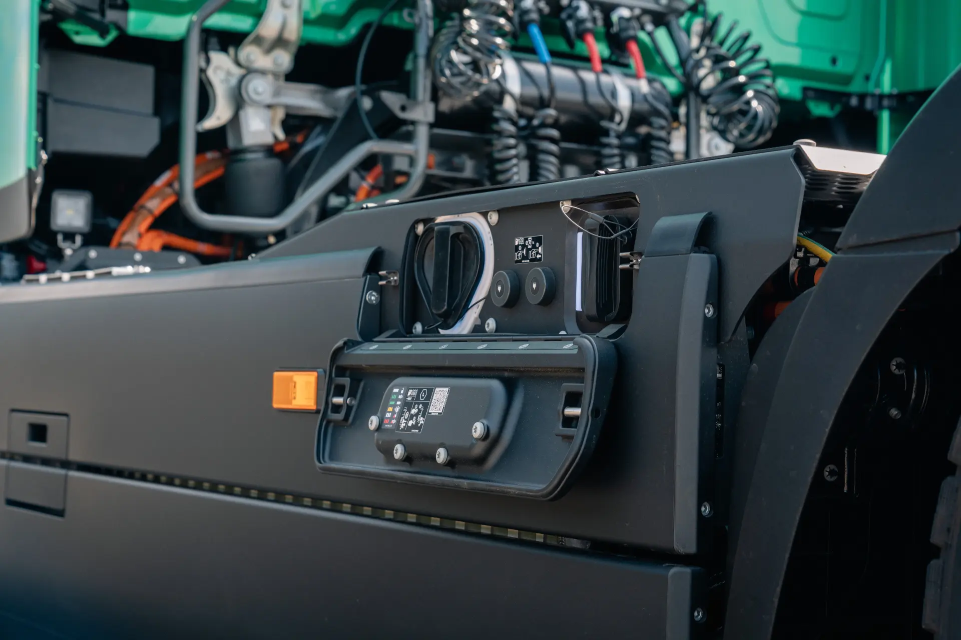 Primer plano de un puerto de recarga de un camión eléctrico con los cables y conectores a la vista, en el que se muestra el innovador eActros 600 de Mercedes-Benz Trucks, una solución ideal para el transporte de gran volumen.