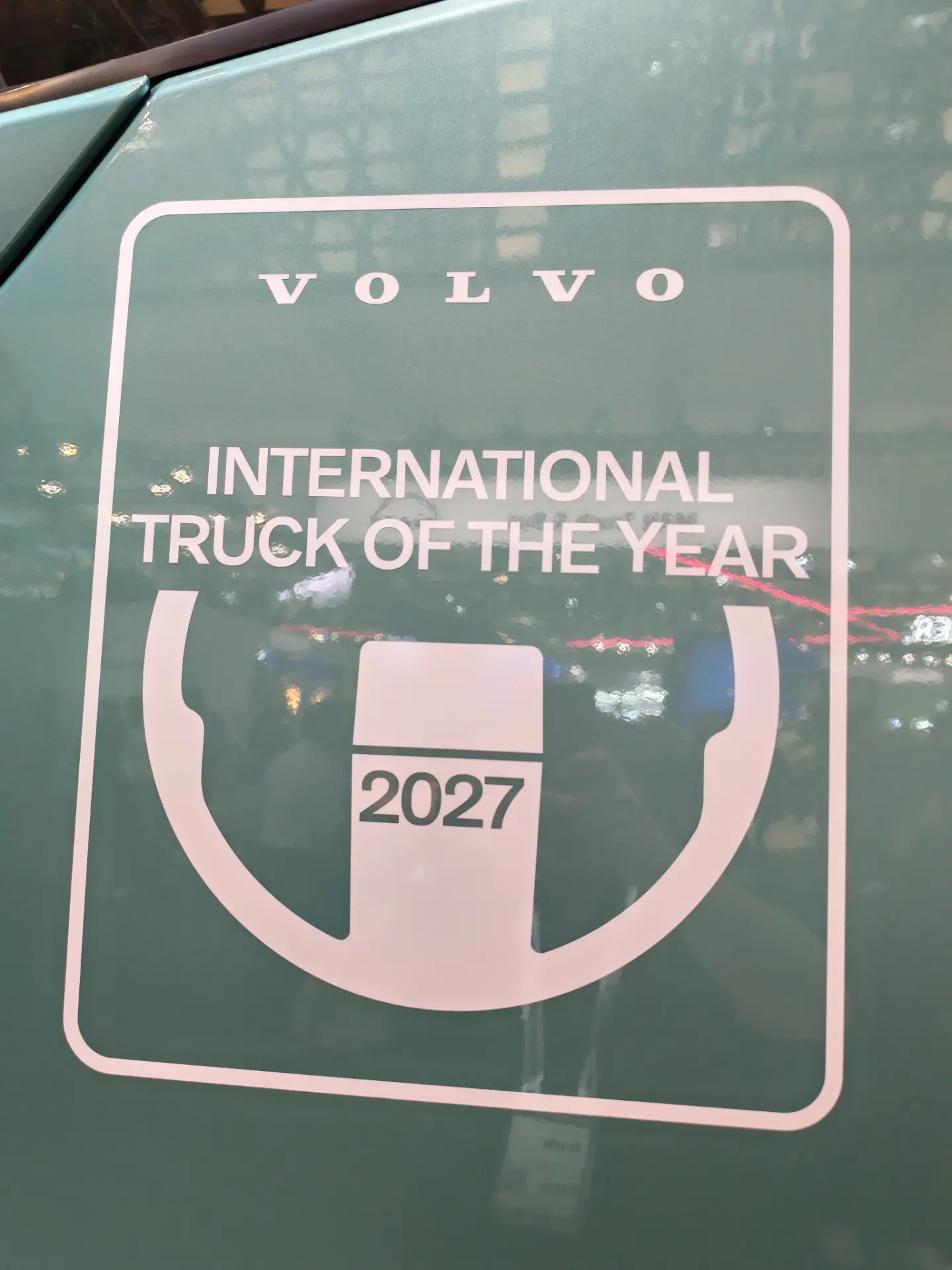Logotipo de «Volvo International Truck of the Year 2027 Borrador automático» en la ventanilla de un vehículo.