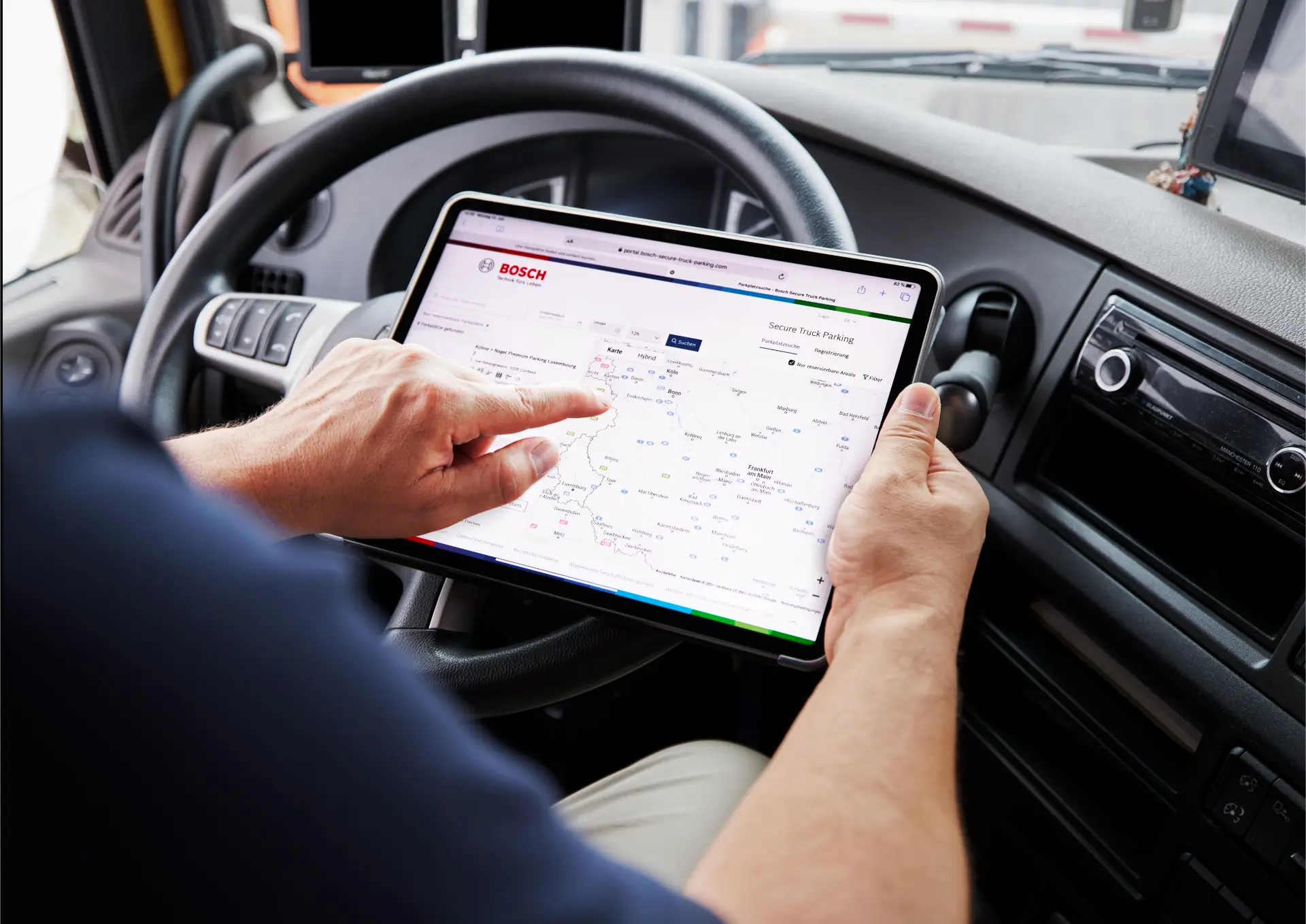 Una persona que viaja en un vehículo utiliza una tableta en la que se muestra una aplicación de mapas de Bosch y toca la pantalla con un dedo, mientras que la función «borrador automático» garantiza que las anotaciones en el mapa se mantengan ordenadas y actualizadas.