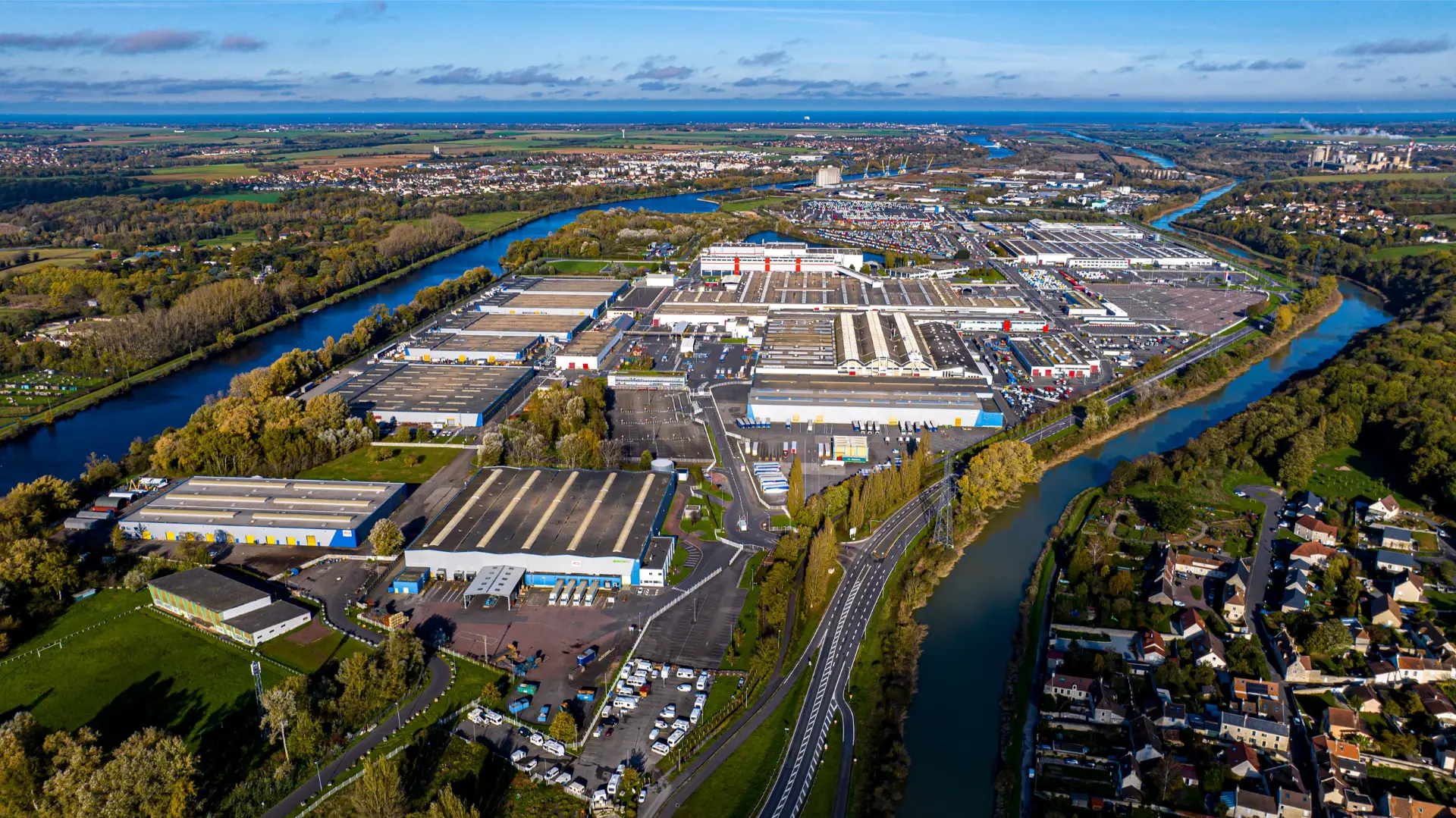 Vista aérea de un complejo industrial situado junto a un río, que parece un boceto técnico.
