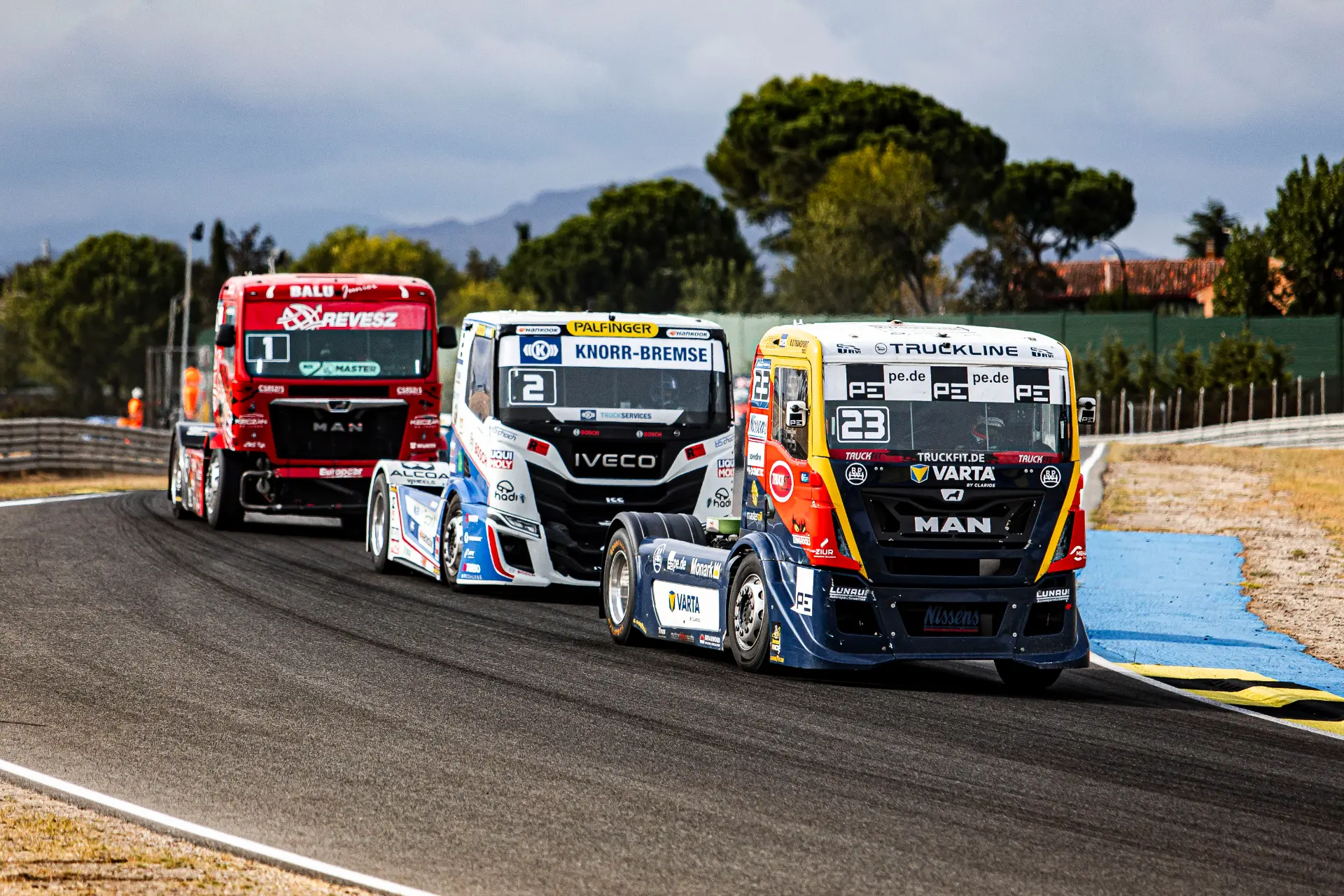 Tres camiones de carreras pilotados por Norbert Kiss circulan uno detrás de otro por una curva en Jarama.