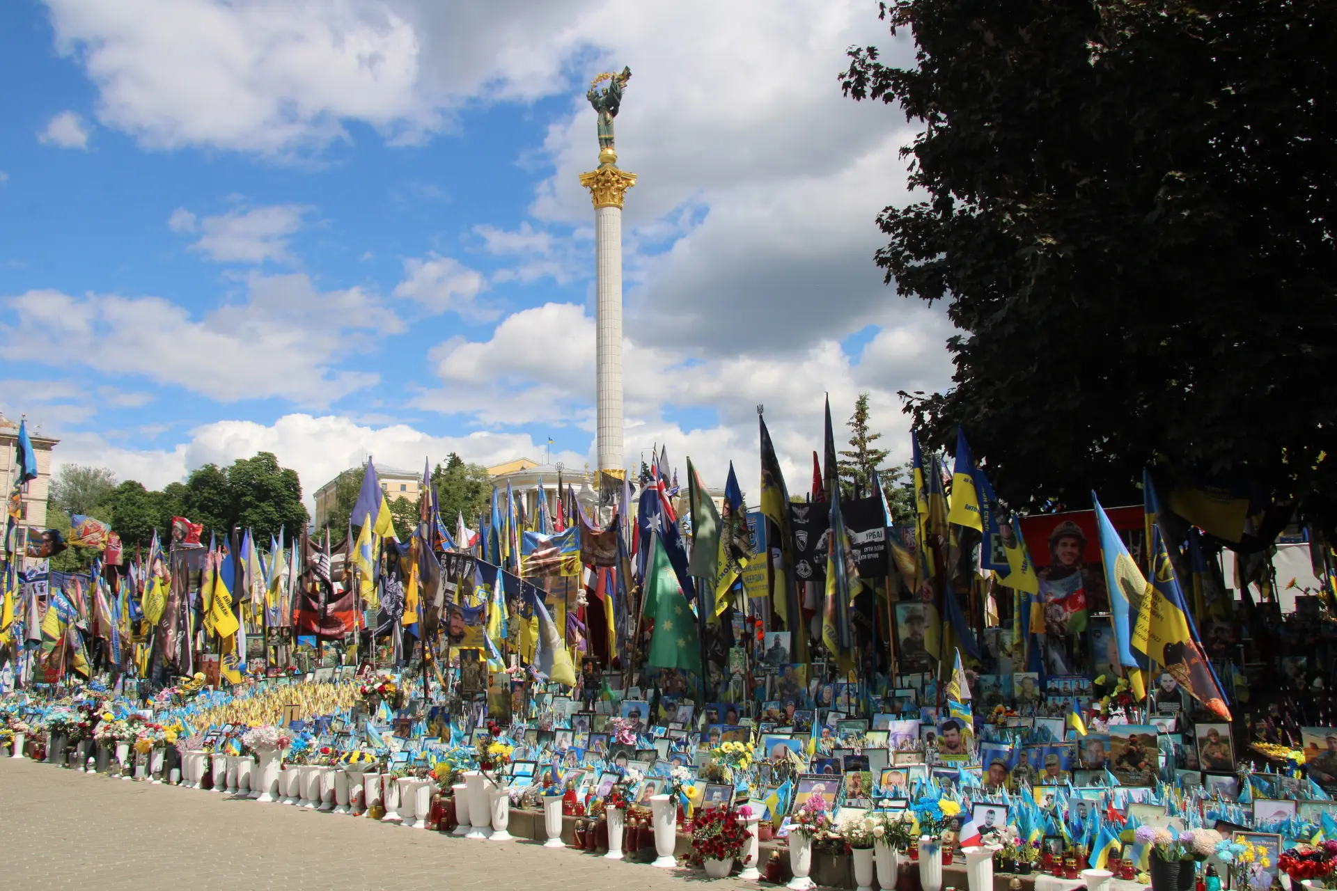 Banderas ucranianas y retratos en un monumento conmemorativo de Kiev, donde las mujeres camioneras se enfrentan a la escasez de personal.