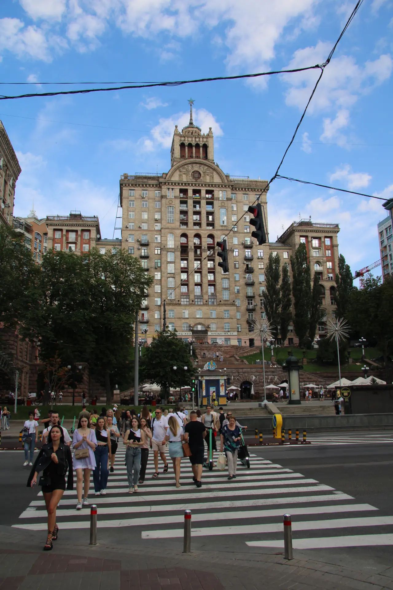 Unos peatones cruzan un paso de peatones en Kiev, cerca de un edificio, reflejando el espíritu de Ucrania.